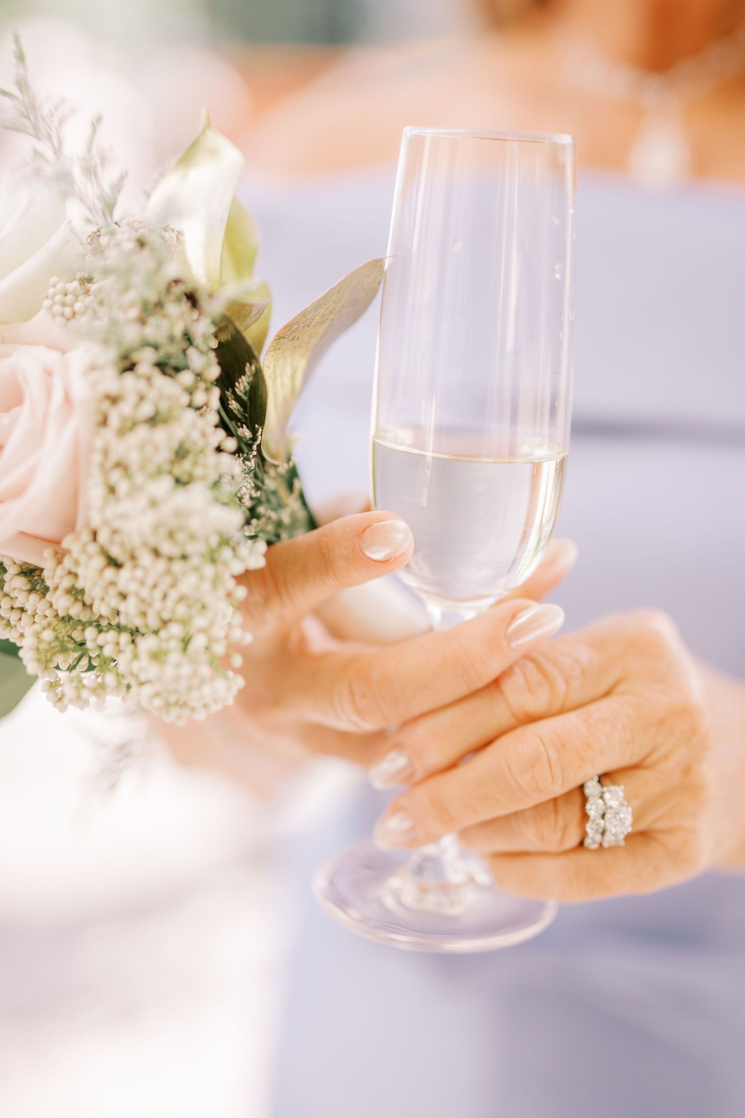 Elegant champagne glasses with delicate white baby's breath flowers create a soft, romantic wedding atmosphere.