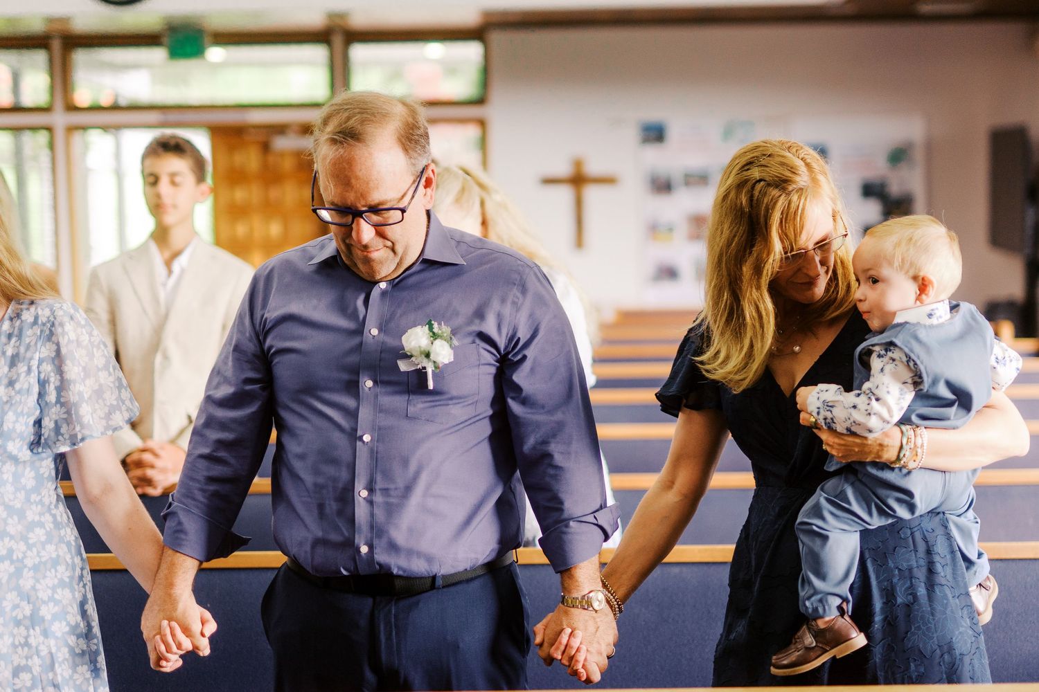 Wedding ceremony scene in church sanctuary with blue decor accents.