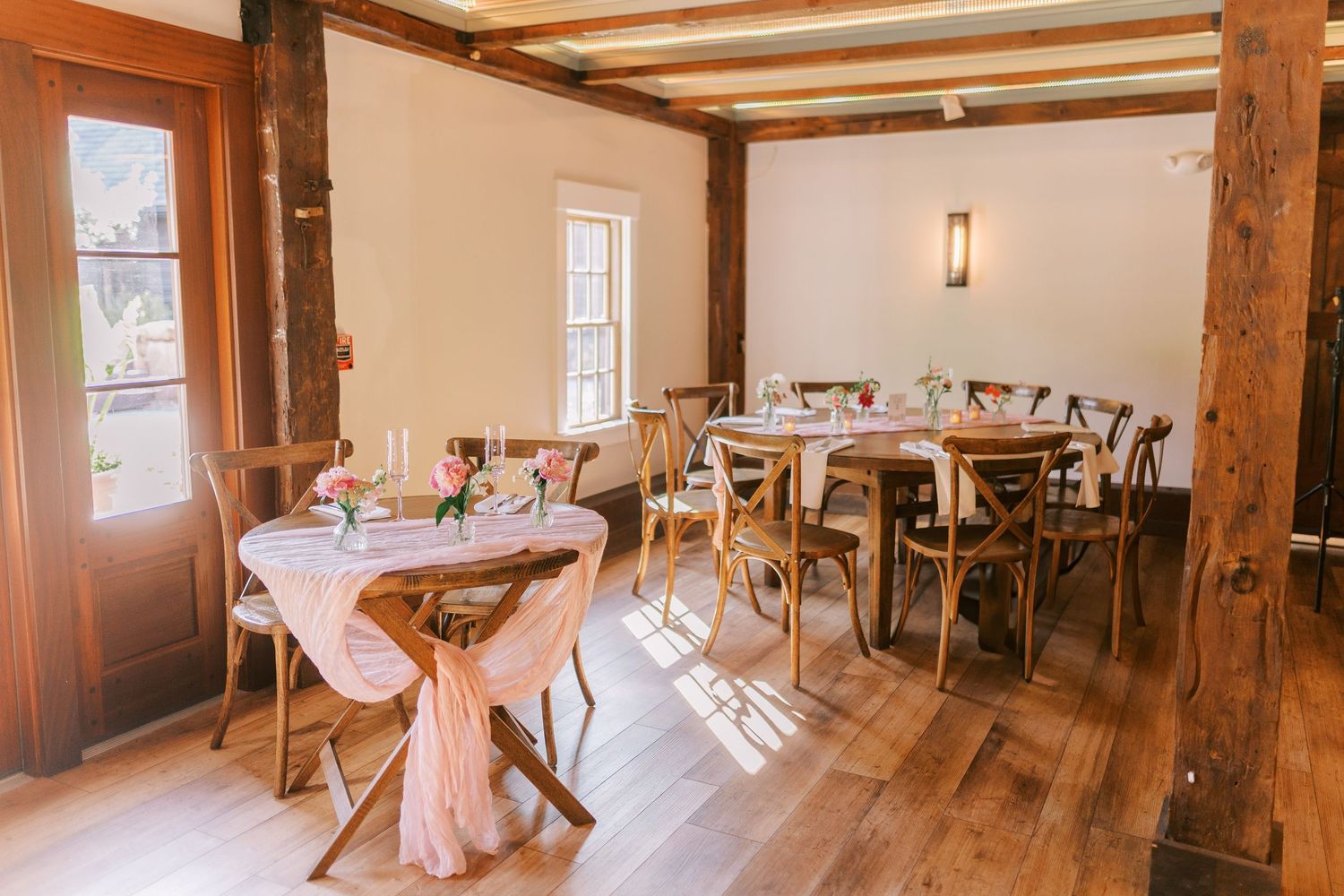 Rustic wedding reception venue with wooden beams and elegant table settings.