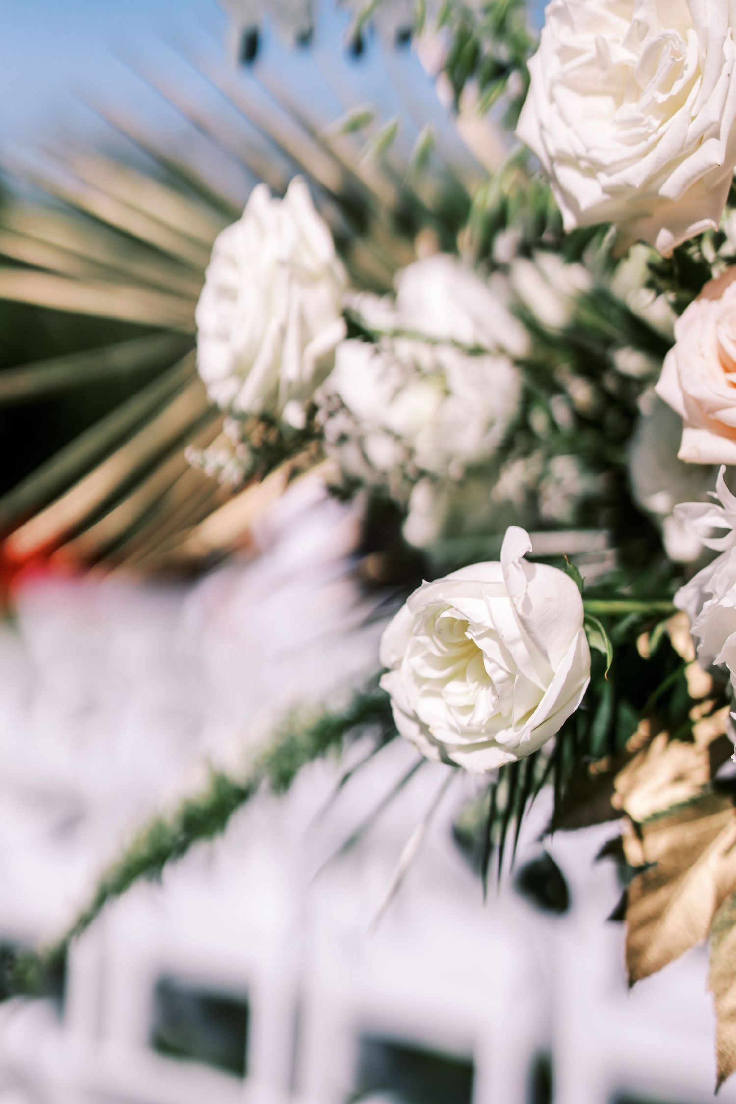 White roses and delicate floral arrangements create an elegant wedding backdrop against a soft blurred background.