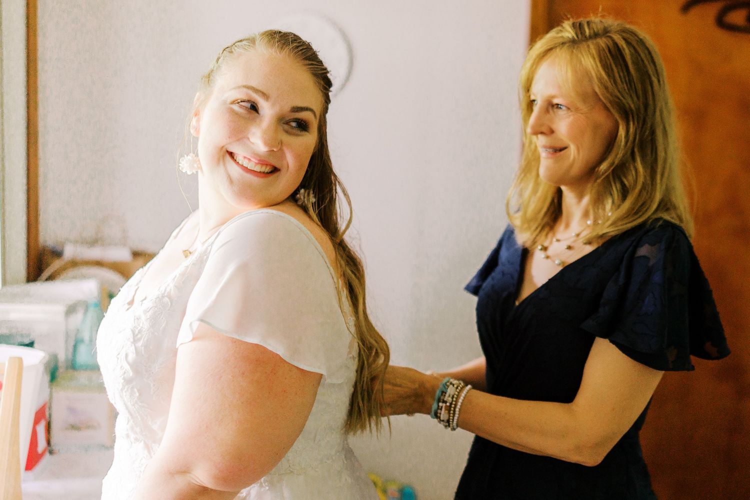 Two people in a getting-ready room during a wedding celebration.