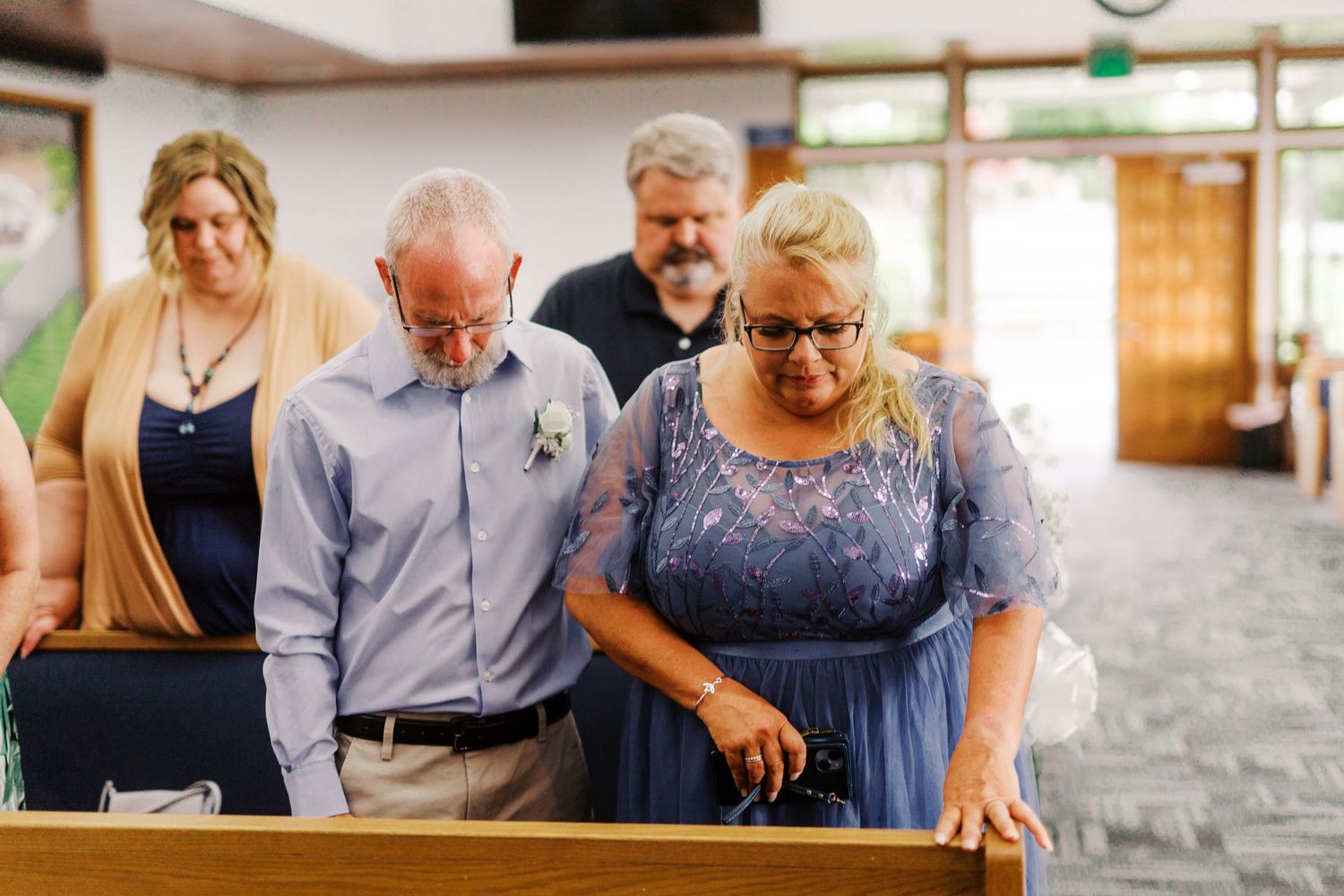 A joyful moment shared between guests in formalwear during a wedding ceremony.