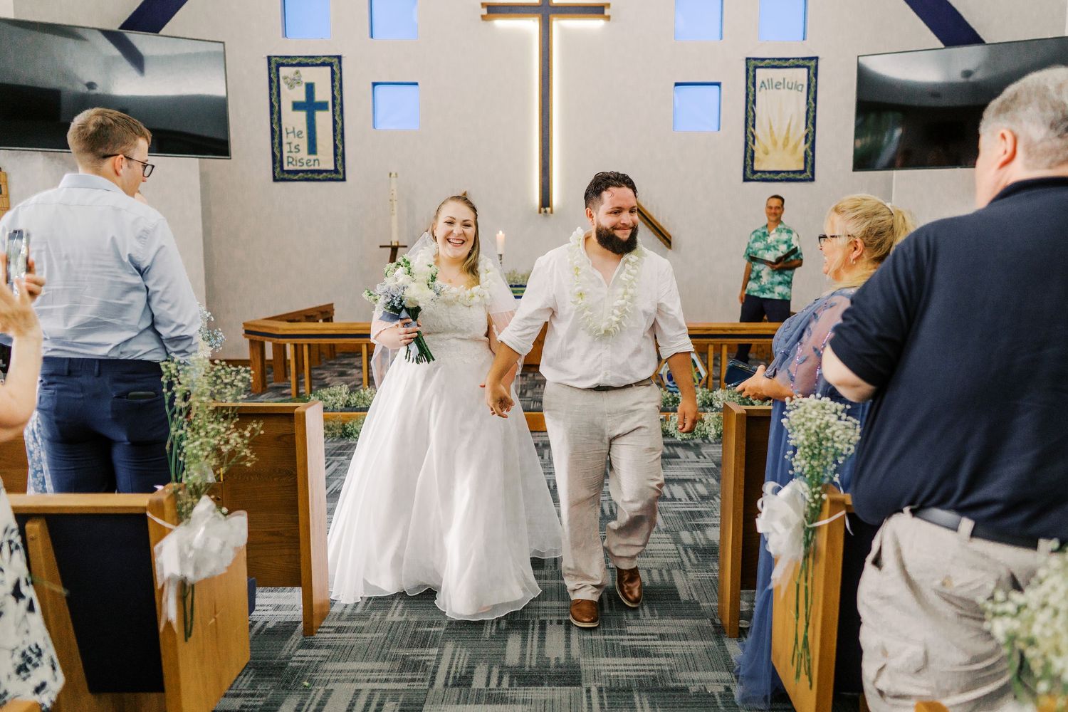 A newlywed couple walking down the church aisle together after their ceremony.