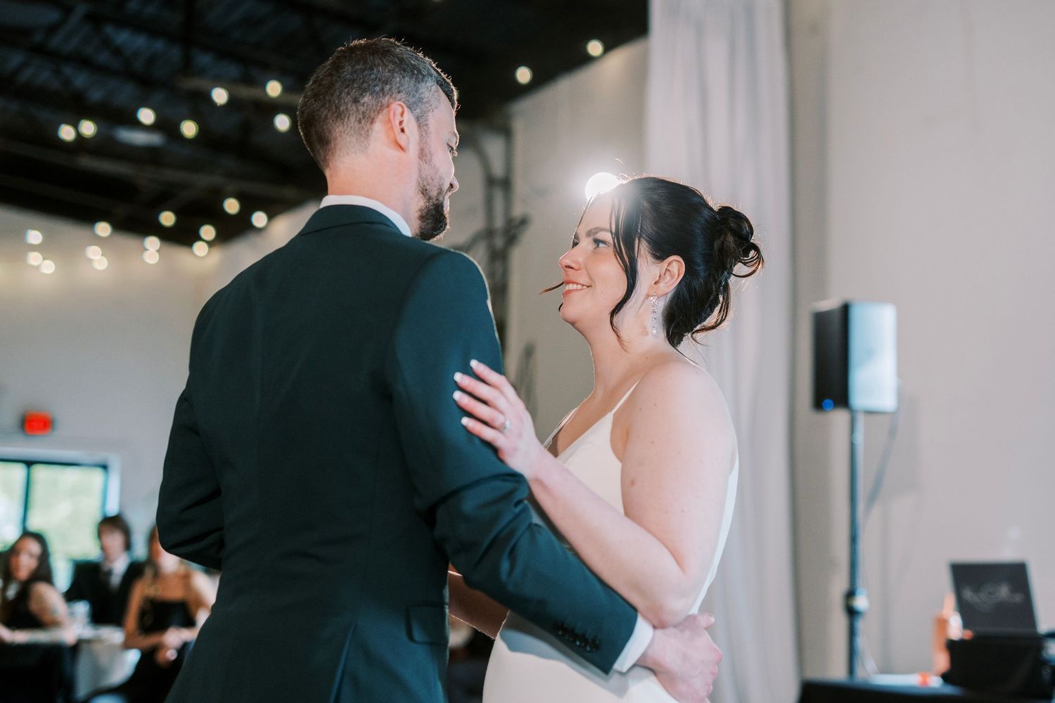 Couple shares intimate moment during first dance at wedding reception.