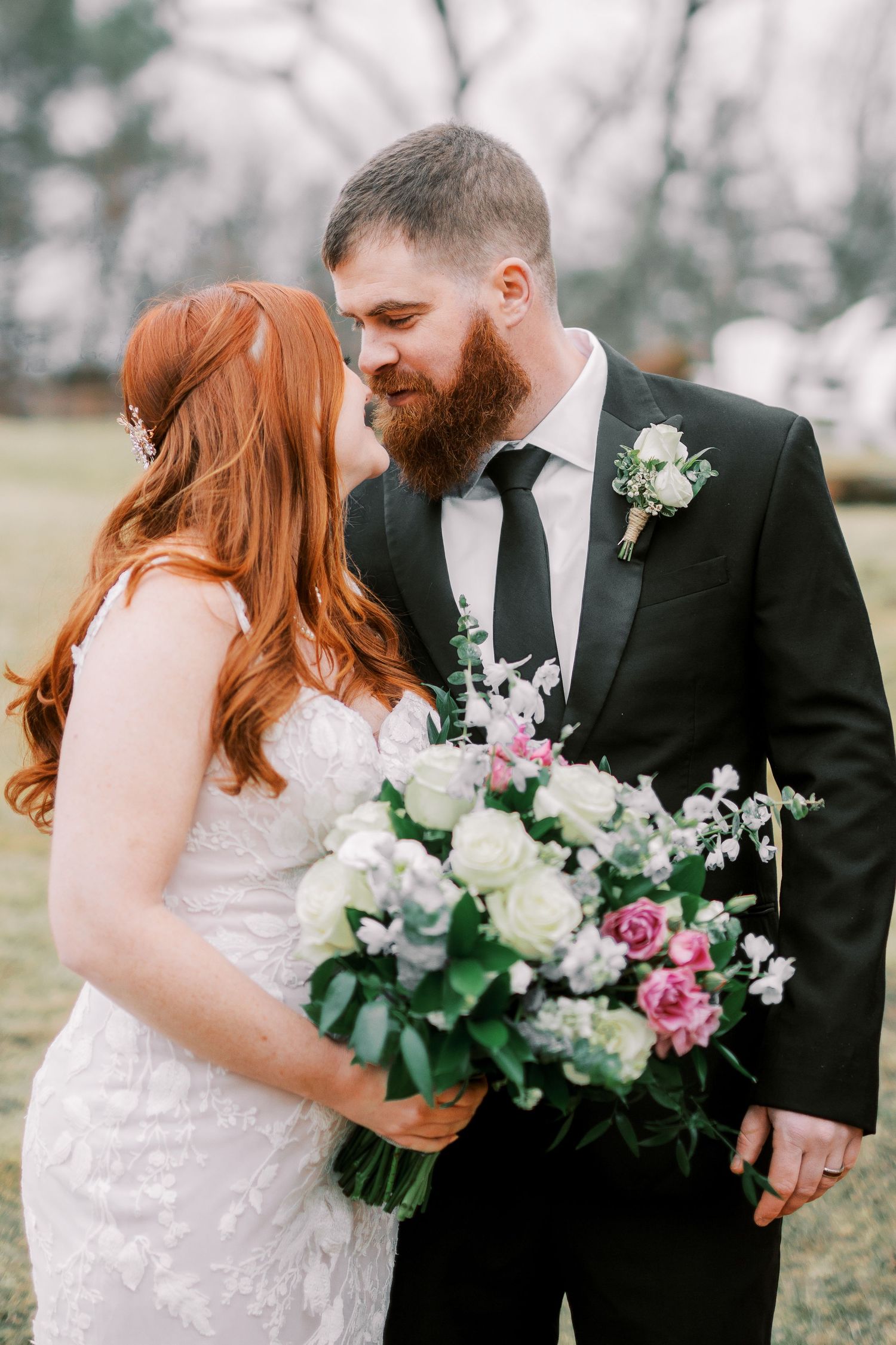 Romantic outdoor wedding portrait with beautiful floral bouquet and natural scenery.