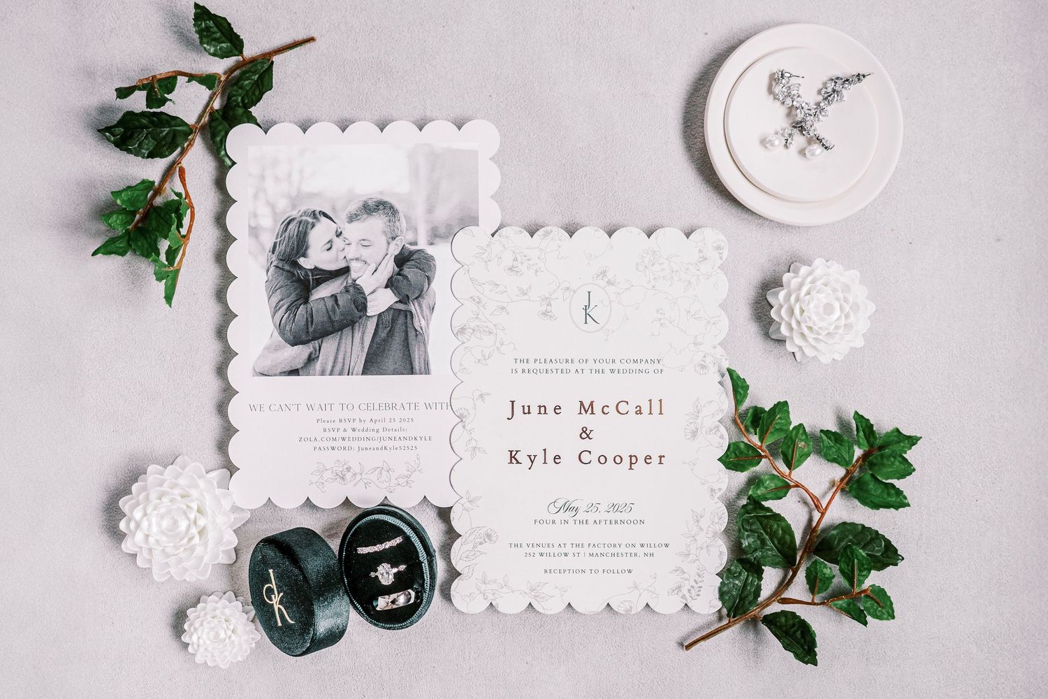 Elegant wedding invitation suite featuring a vintage photo, monogram, and decorative greenery details on a light fabric background.