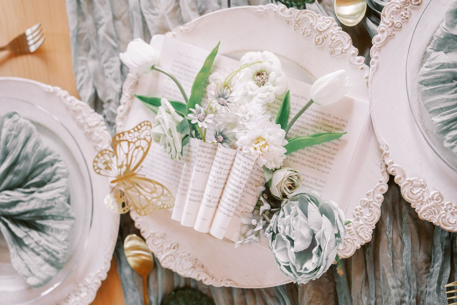 Delicate white gift boxes with silver ribbons and floral decorations arranged in an elegant holiday display.