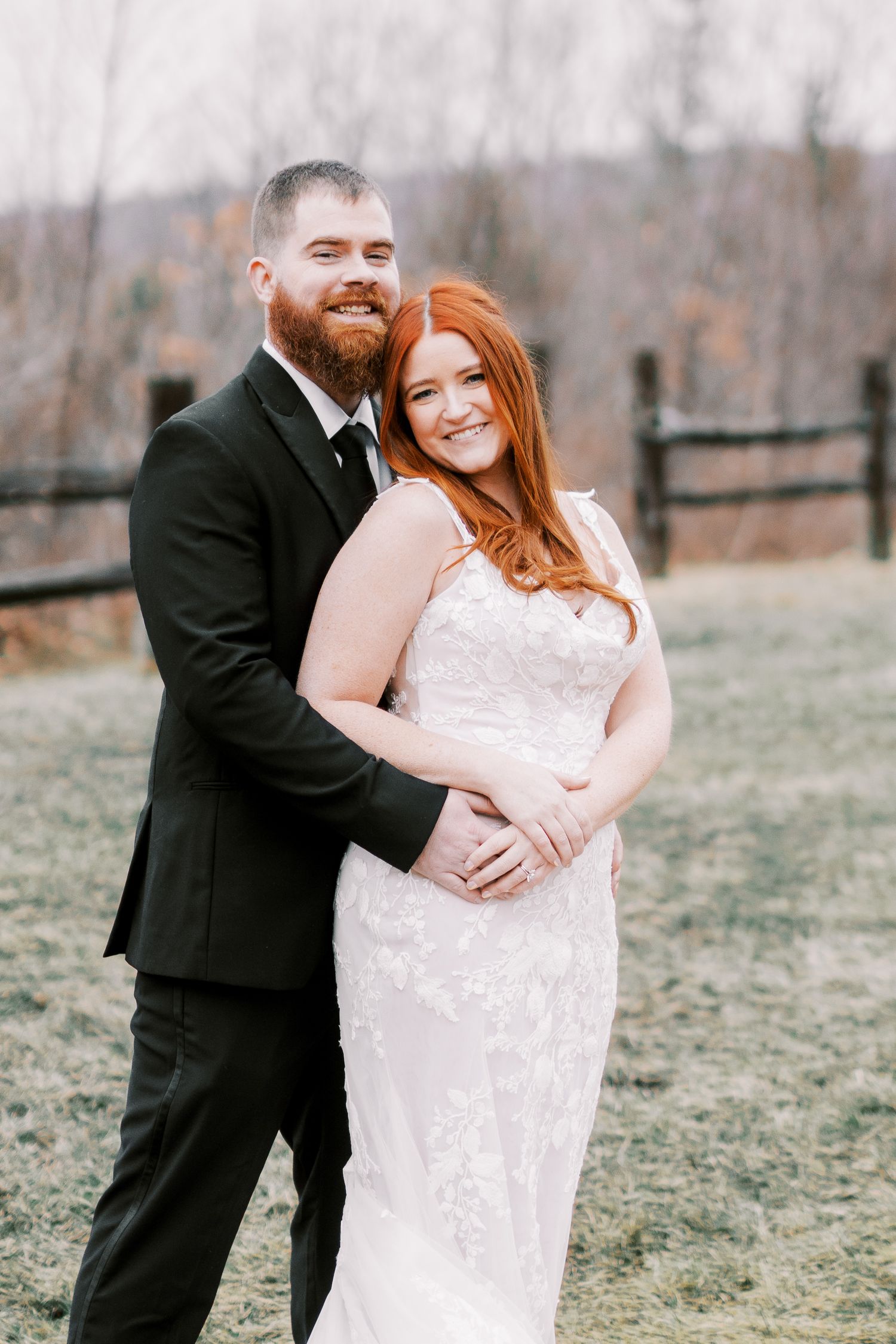 A romantic outdoor wedding portrait in a rustic field during the fall season.