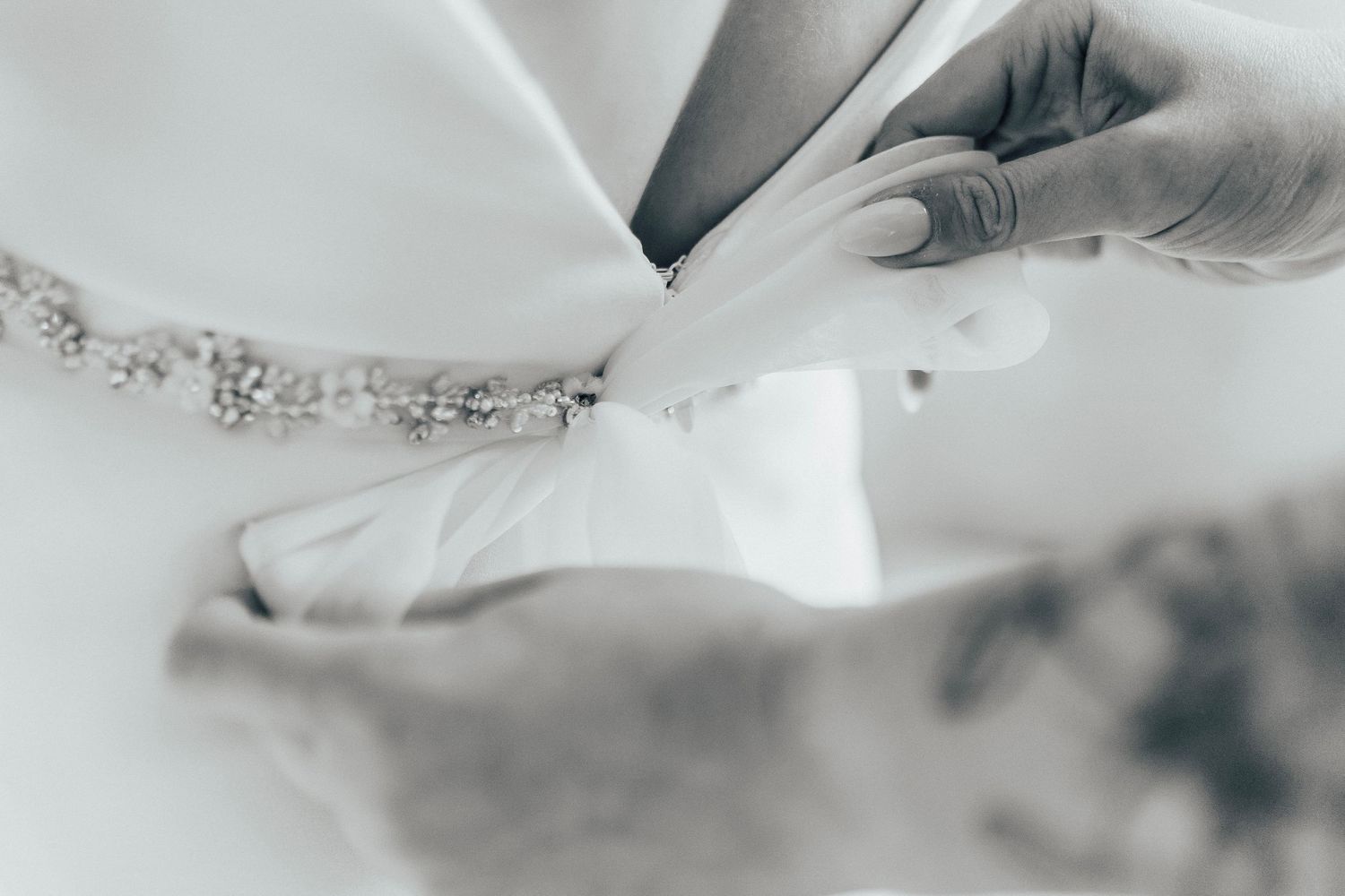 Their hands gently fold white dough on a floured marble countertop in preparation for baking.