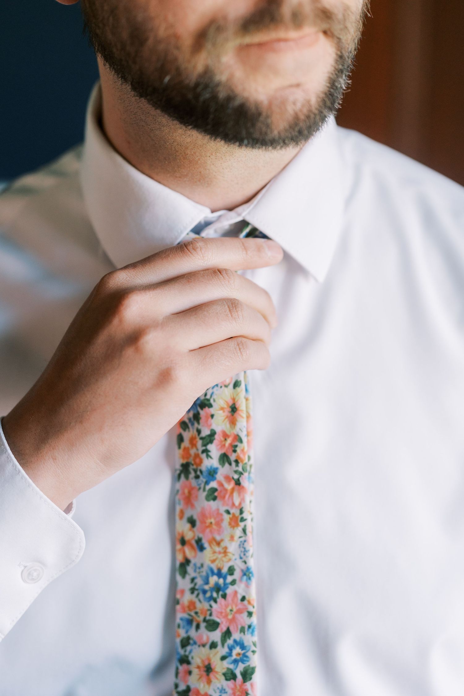 Detailed view of floral print tie against crisp white dress shirt.