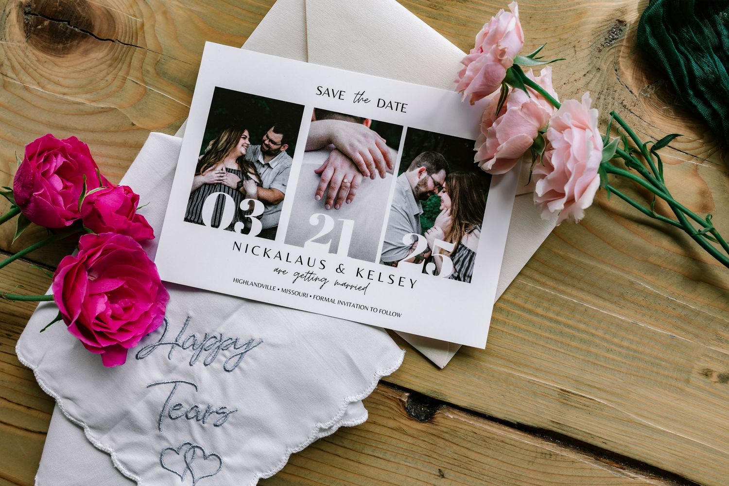 Wedding photos and save the date cards displayed on wooden surface with pink roses and carnations as decoration.