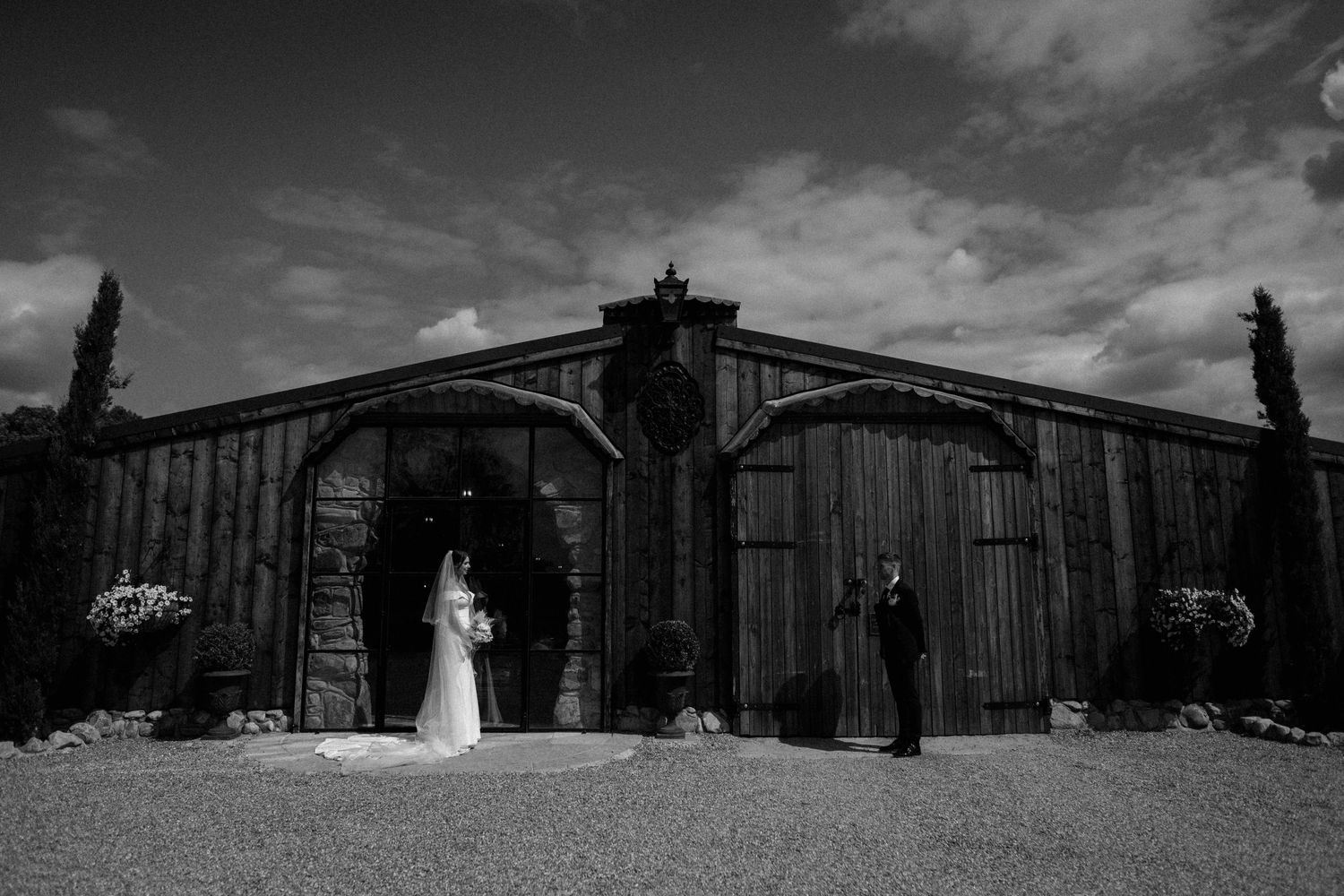 A collection of dramatic black and white wedding photos showing couples at a rustic barn venue. Wedding photography at Willow Marsh Farm.