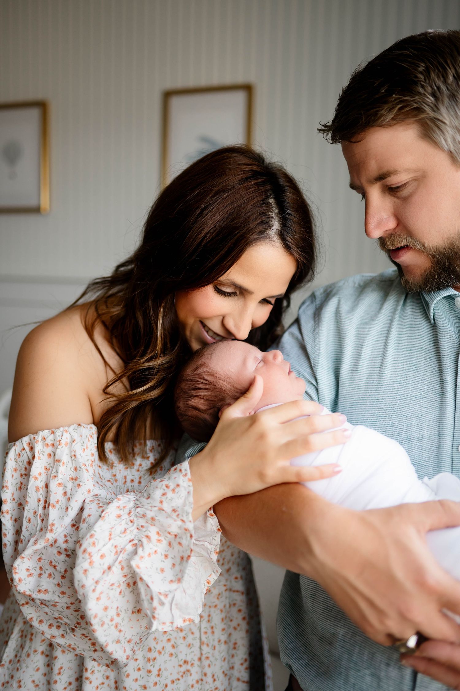 Parents lovingly gaze at their newborn baby in an intimate indoor portrait with best Durham newborn photographer