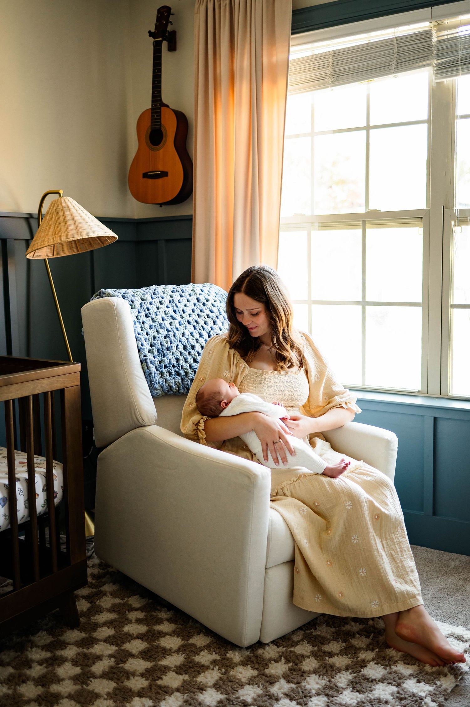 A cozy nursery scene with a rocking chair, acoustic guitar on the wall, and soft natural light with newborn photographer raleigh nc
