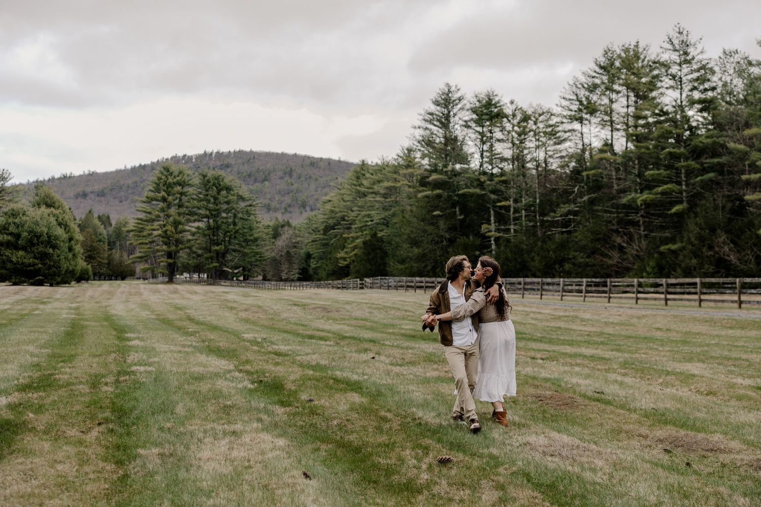 couple dancing in an open field with hills behind them in Upstate New York
