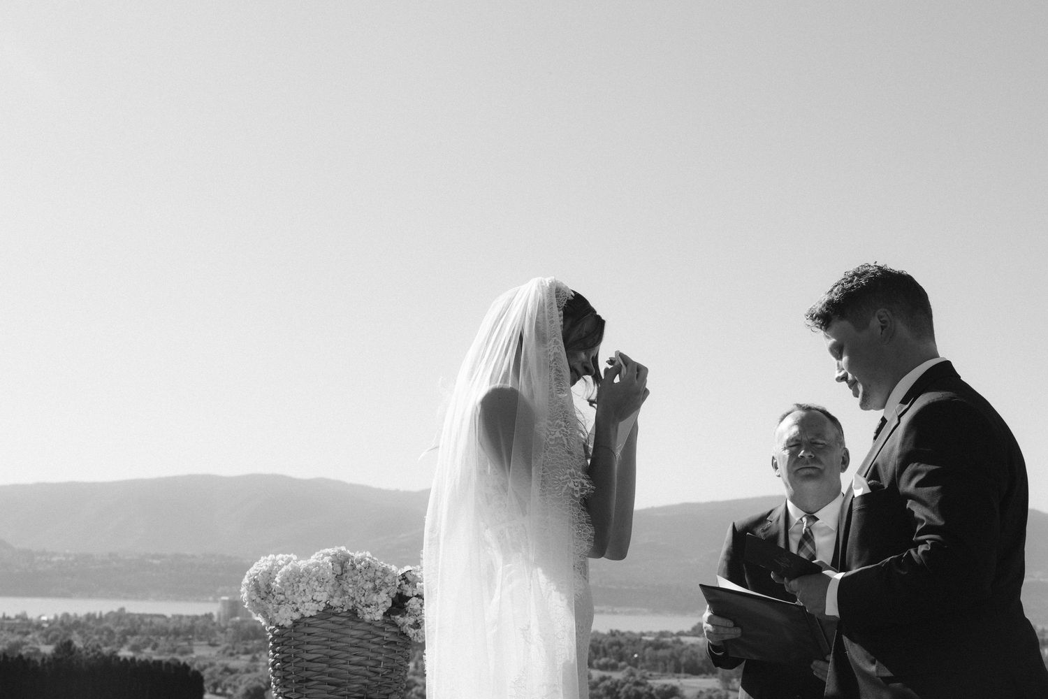 A romantic black and white photo collage shows moments from a wedding celebration overlooking a scenic mountain vista.