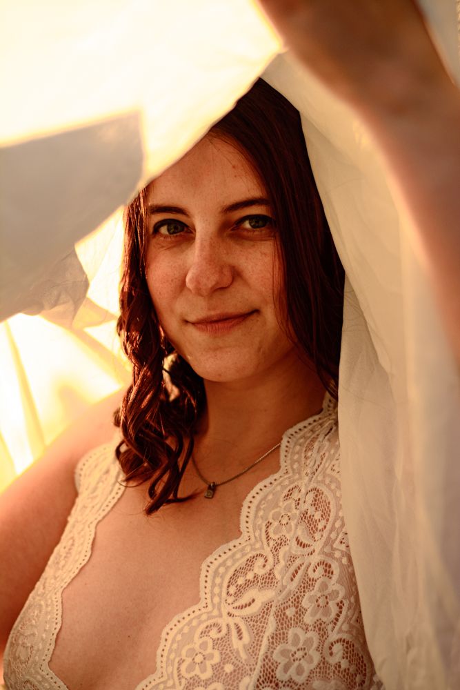 A delicate lace bridal portrait with warm sunlight and flowing veil.