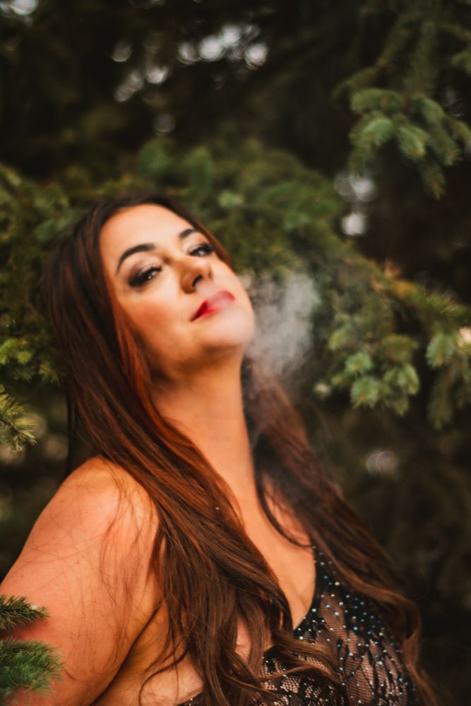 Ethereal portrait against pine trees with smoke effects and lace details.