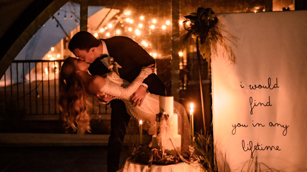 Romantic candlelit wedding scene with embracing couple against glowing string lights and handwritten note.
