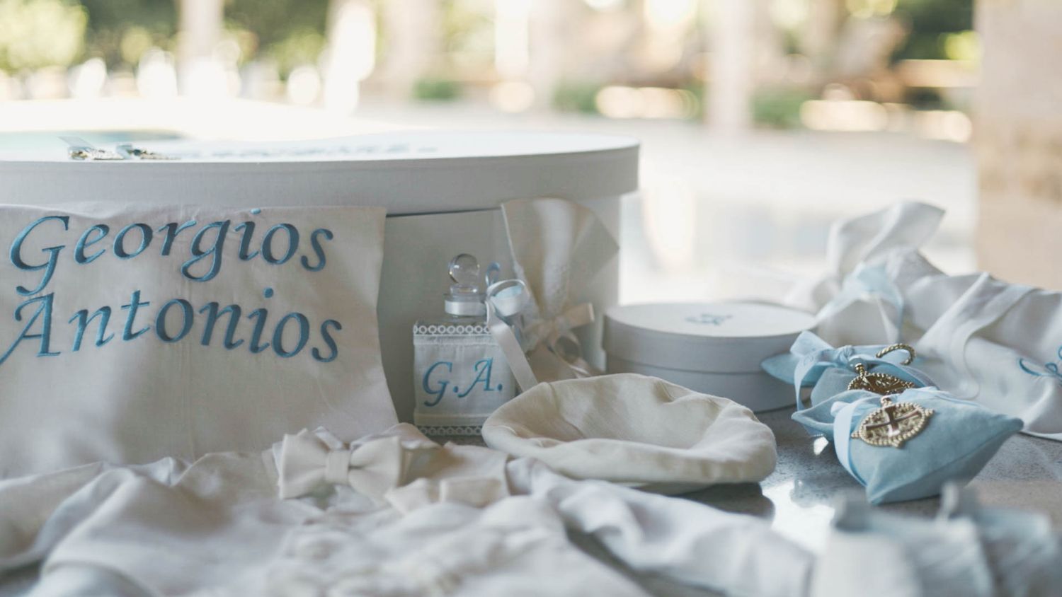 Light blue and white baptism or christening party decorations with personalized name 'Georgios Antonios' on display.