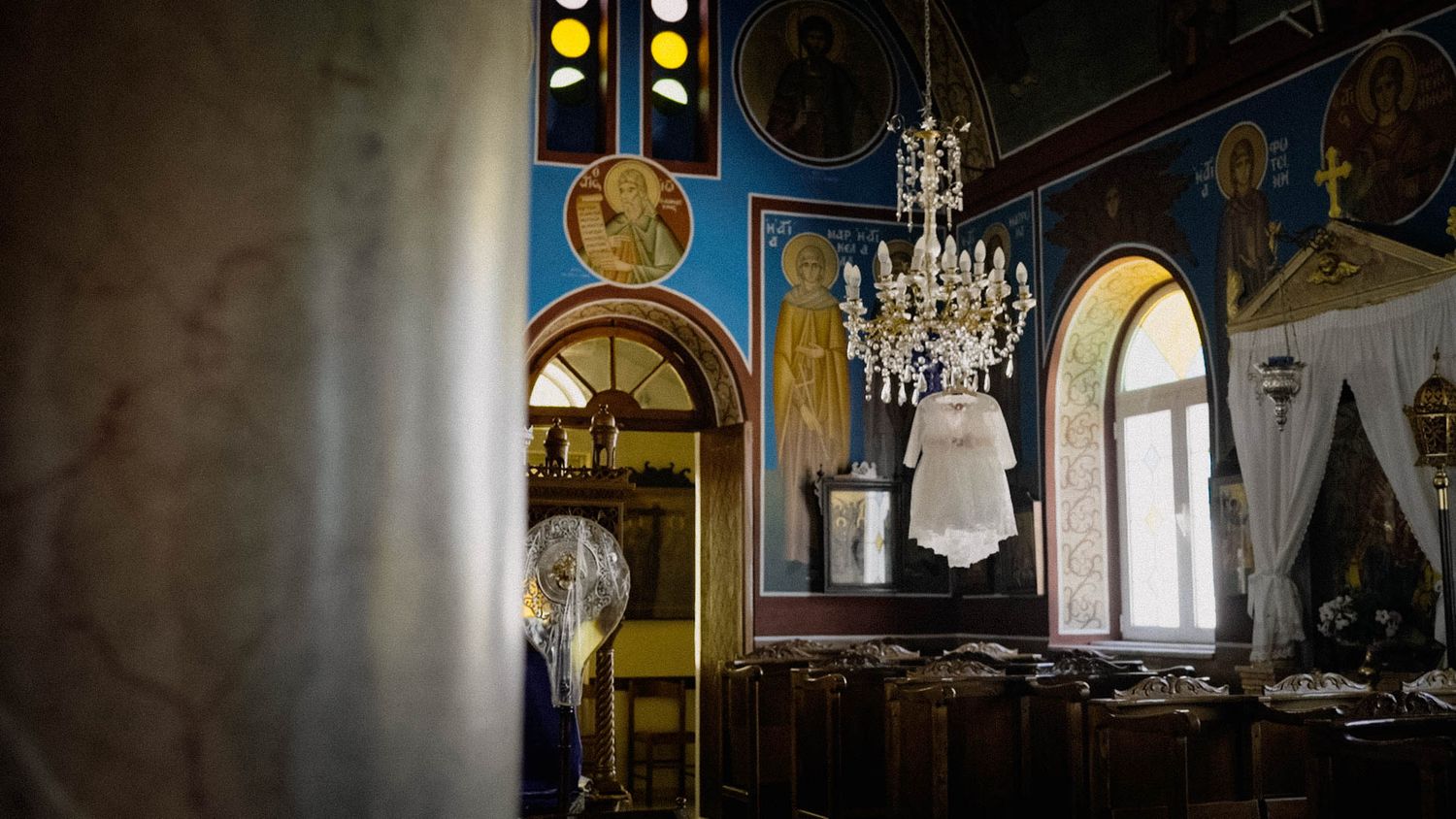 Elegant crystal chandeliers hanging in a vintage room with ornate arches and dramatic lighting.