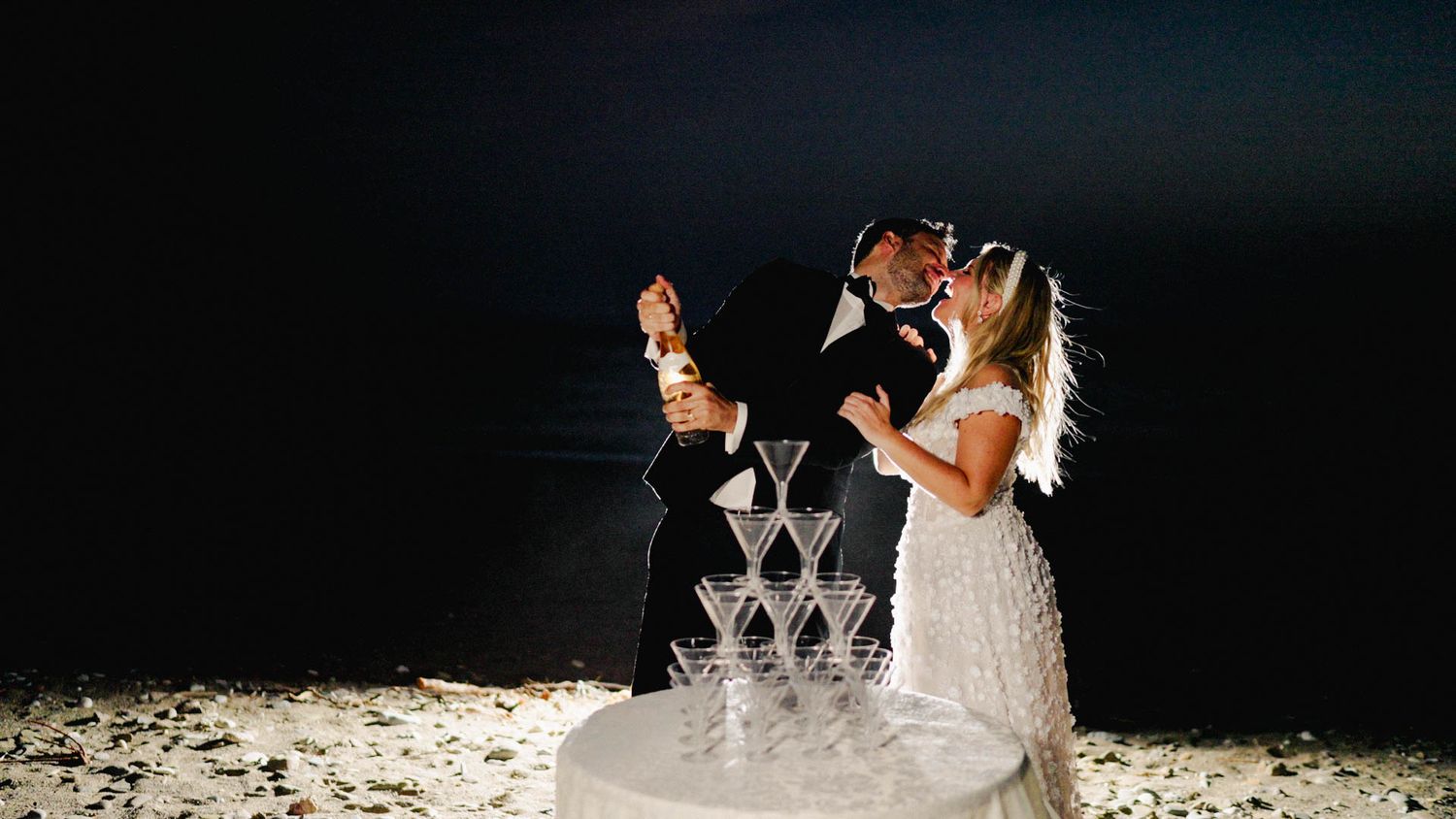 A series of wedding photos featuring moments from a bride and groom's celebration at night with sparklers and dancing.