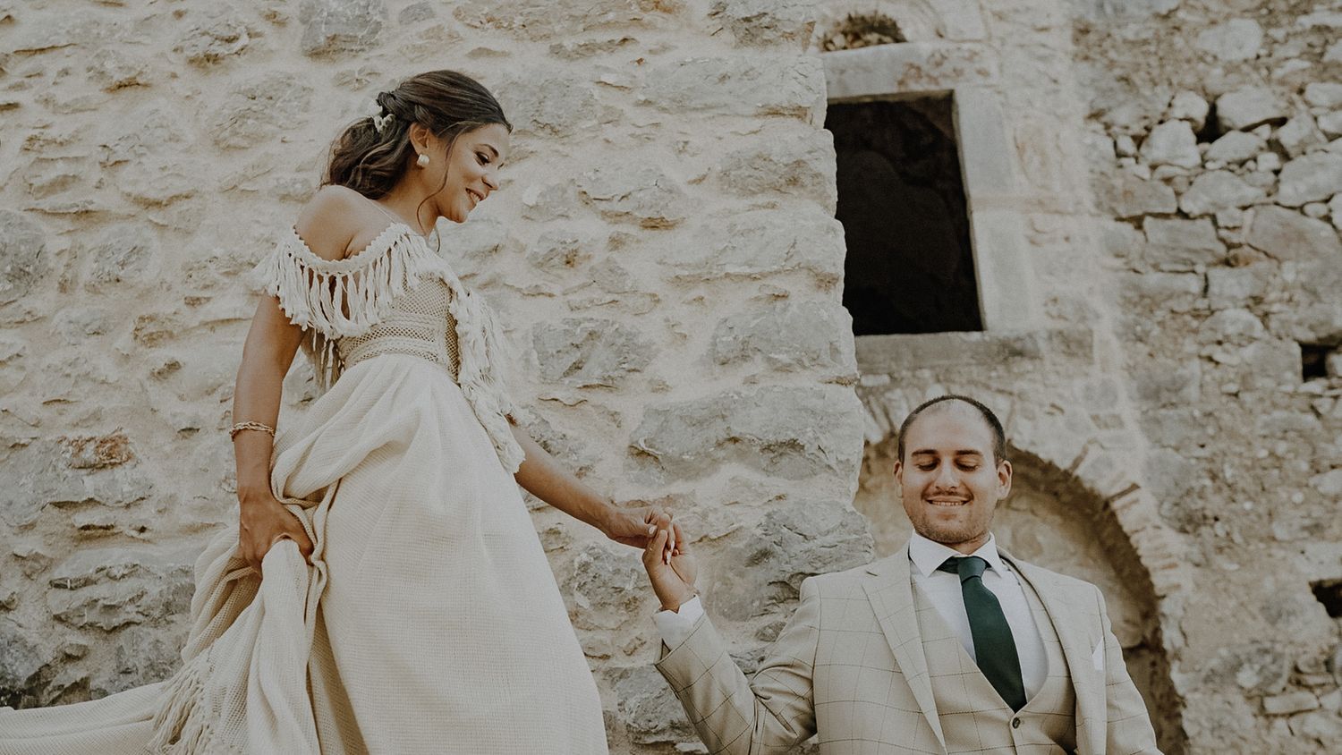 Candid moment of couple on stone steps during wedding photoshoot.