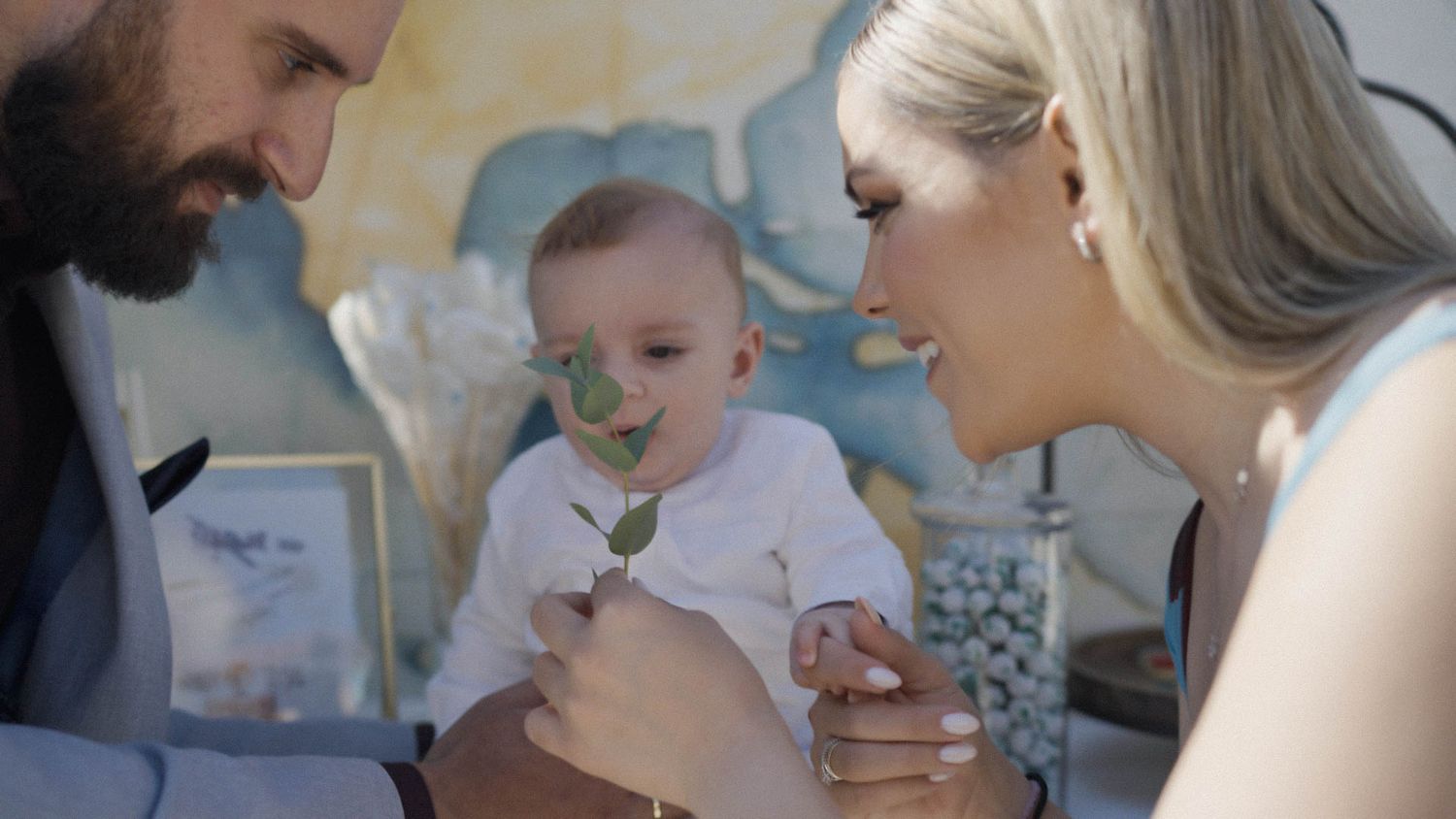 Young couple sharing a tender moment with their baby, smiling and laughing together indoors.