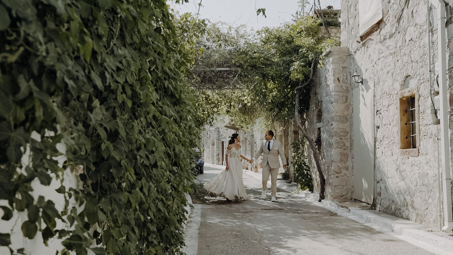 A charming stone alleyway with ivy-covered walls and rustic architecture creates a romantic Mediterranean atmosphere.