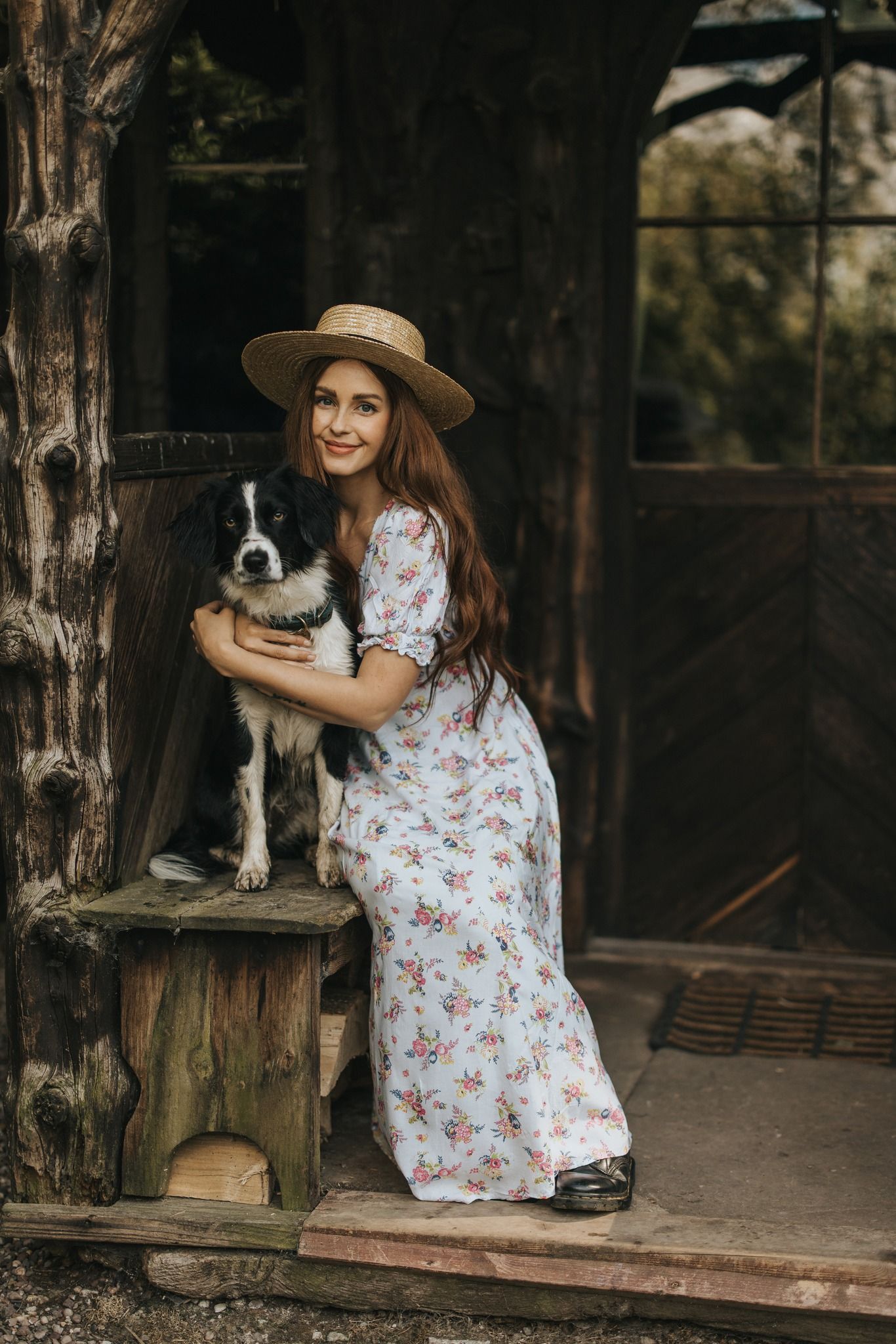 Merika from James Green Studio smiles, sat next to her dog on rustic wooden porch.
