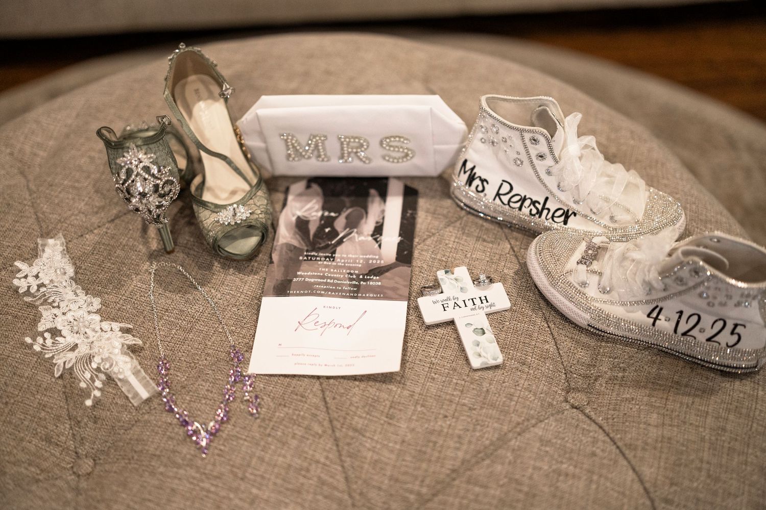 Wedding details including high heel shoes, Mr & Mrs sign, cross, and date display arranged on rustic wooden surface.