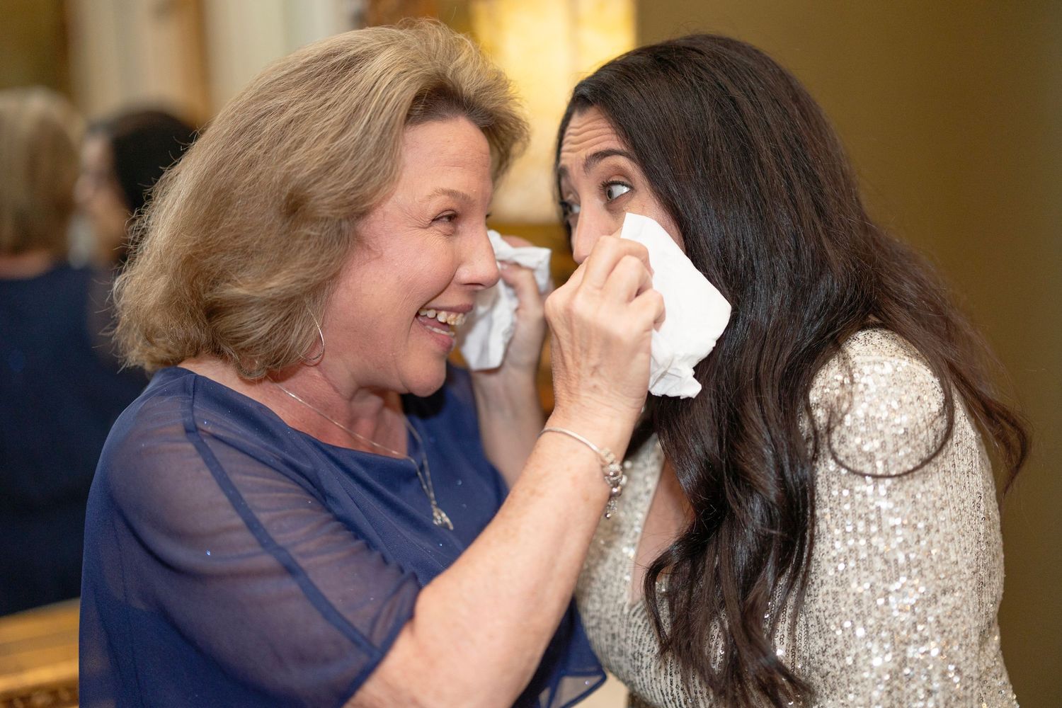 Emotional moment captured as tears are wiped away during wedding reception.