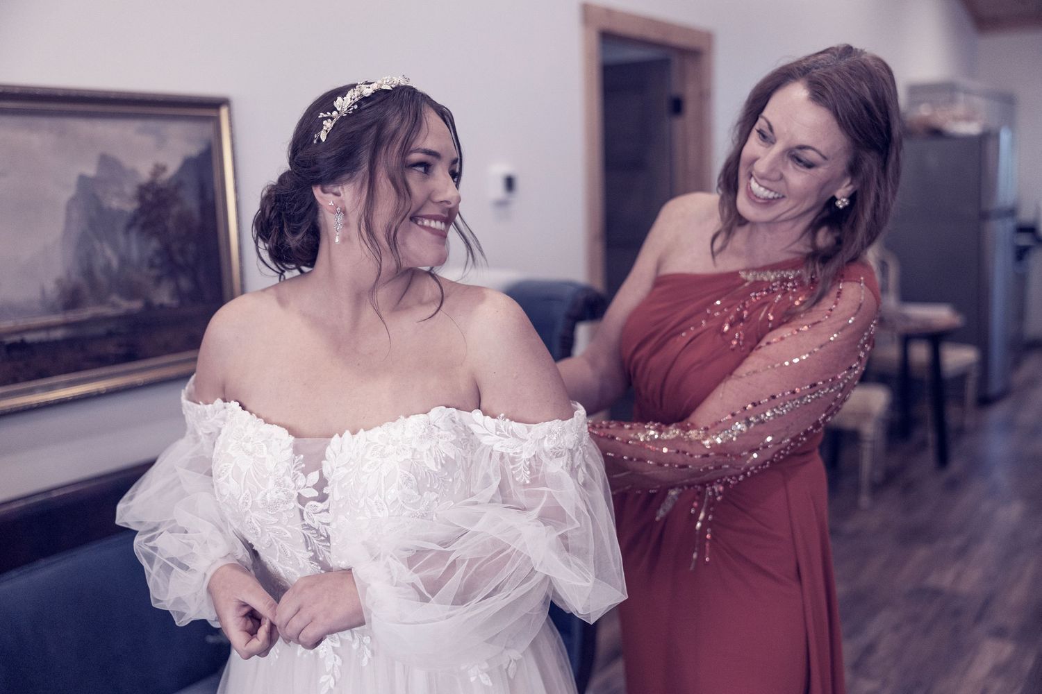 Two people sharing a special pre-wedding moment as they prepare for the ceremony in an indoor setting.