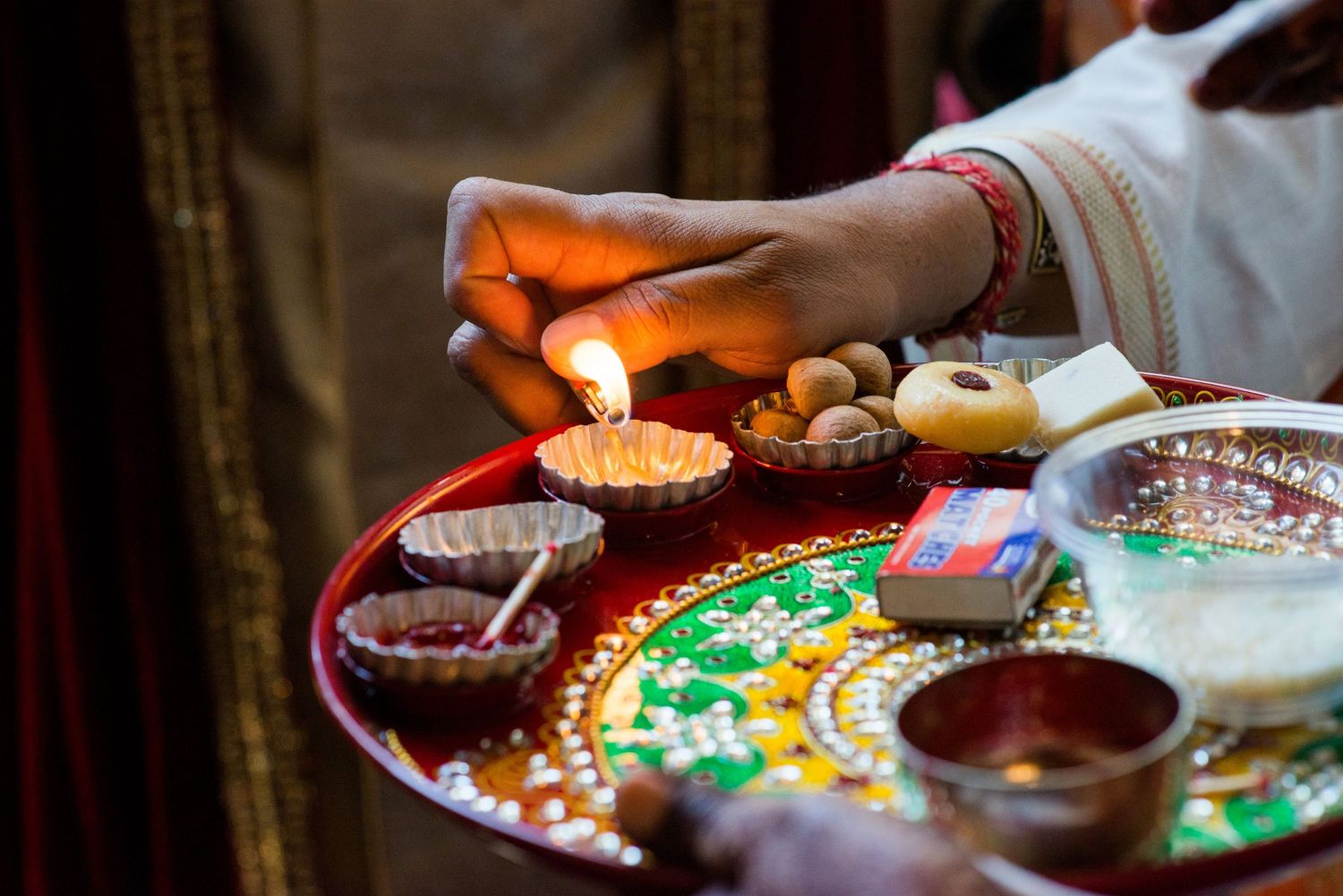 Colorful traditional Indian wedding ceremony items and decorative plates arranged for rituals.