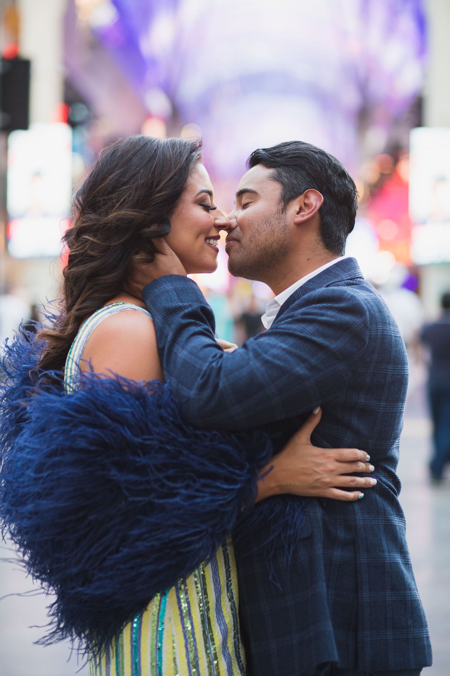 A romantic close-up of a couple about to kiss under city lights.