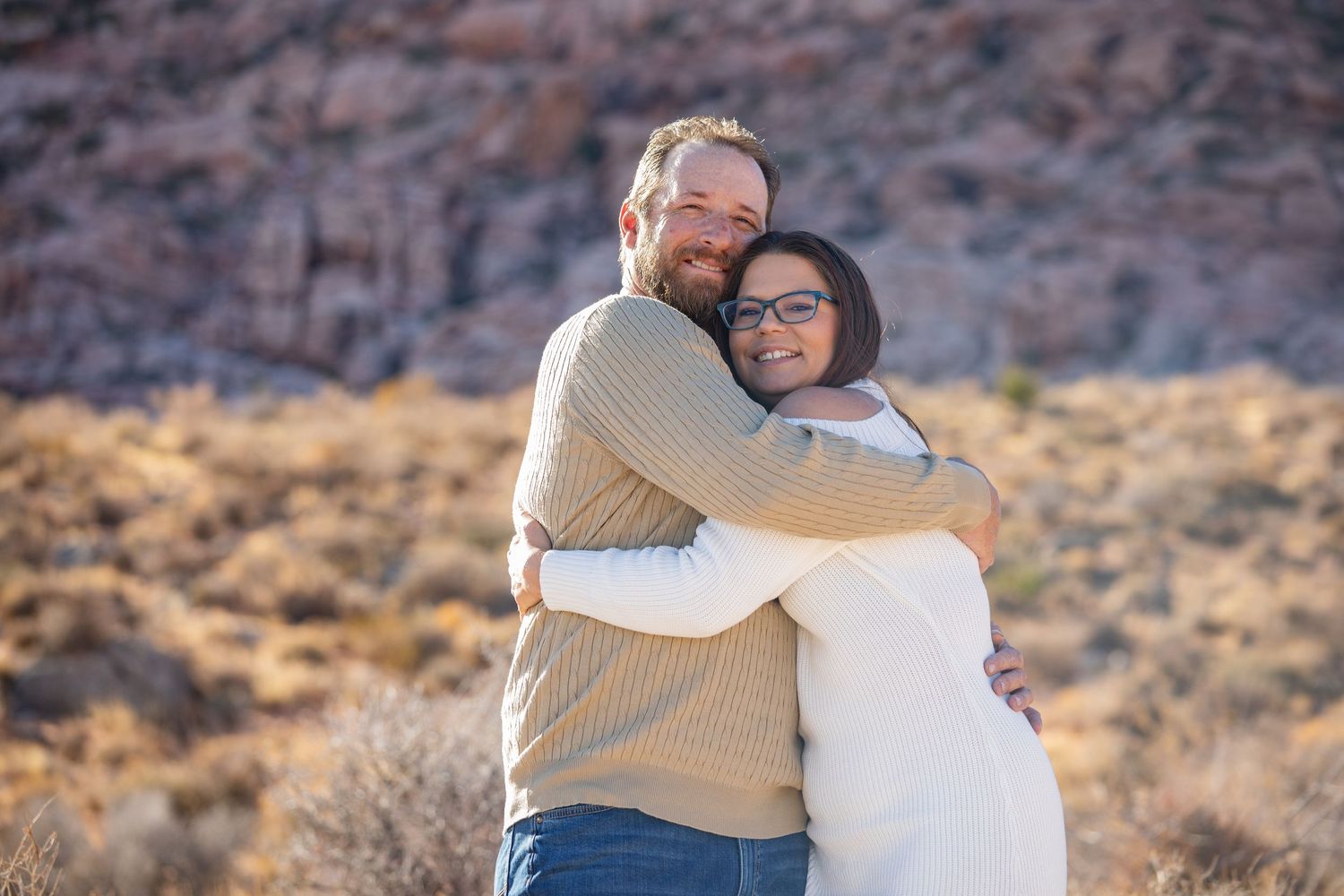 Romantic portrait session against red rock mountains in a desert setting.