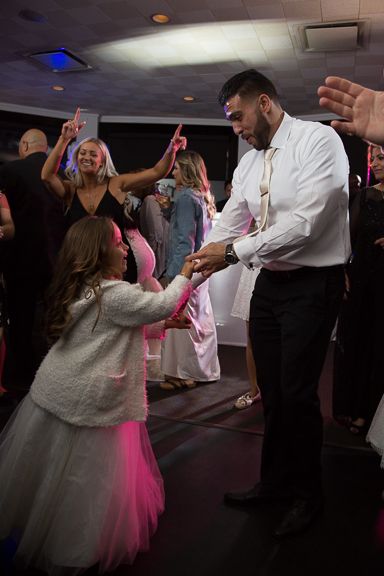 Wedding reception dance party with pink lighting and energetic celebrations.