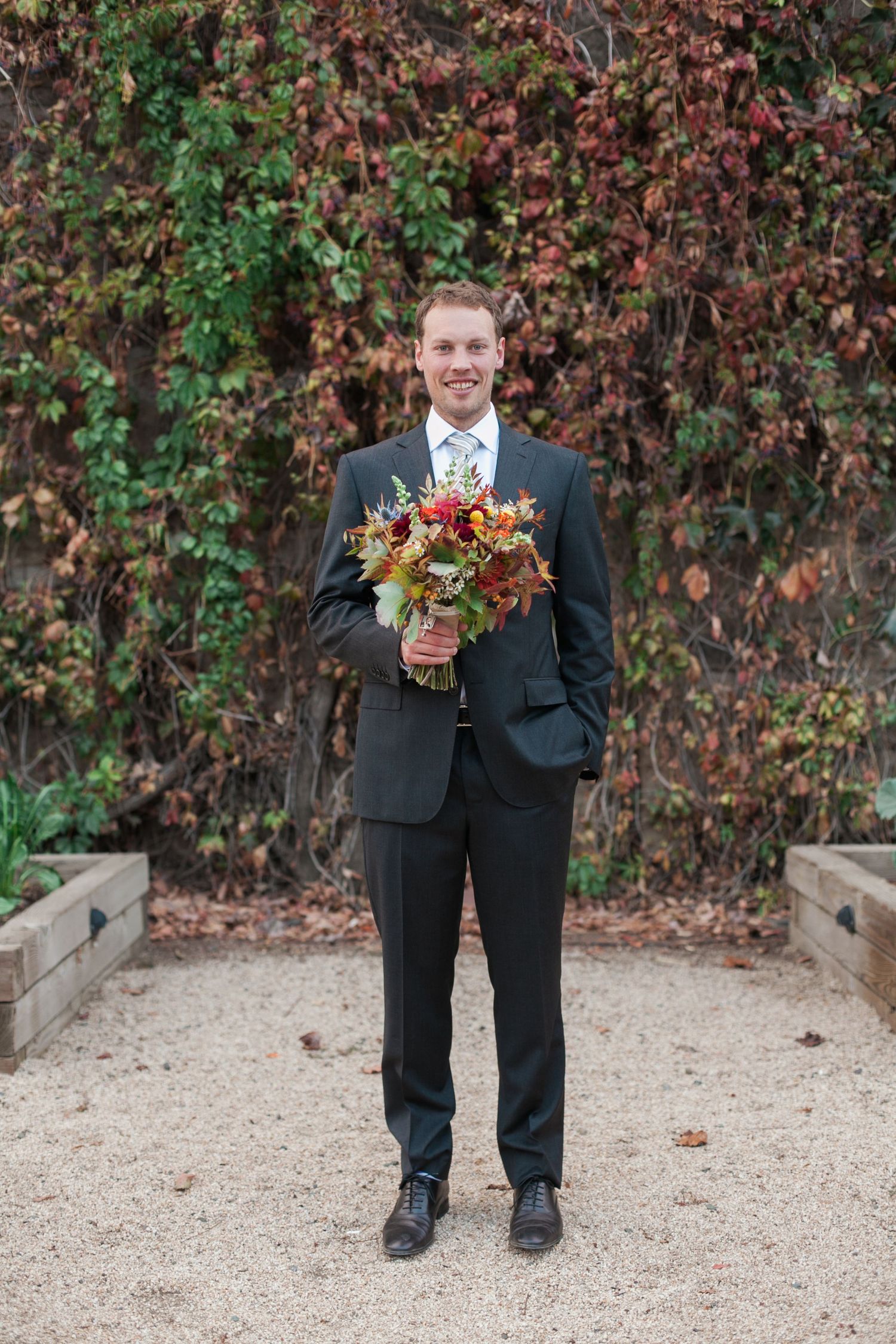 Autumn wedding scene with red foliage and gravel path.
