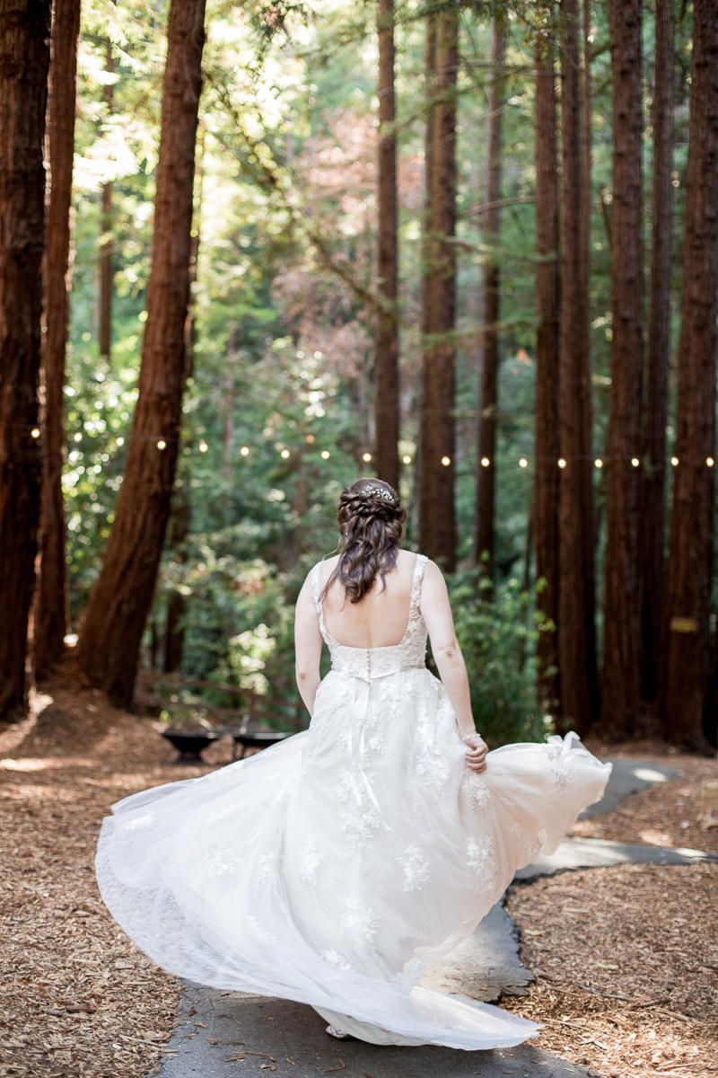 Beautiful forest bridal photo series showing a white wedding dress flowing in gentle motion among towering redwood trees.