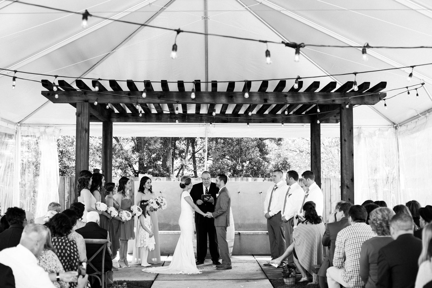 Wedding reception venue with string lights and white tent covering the outdoor celebration space.