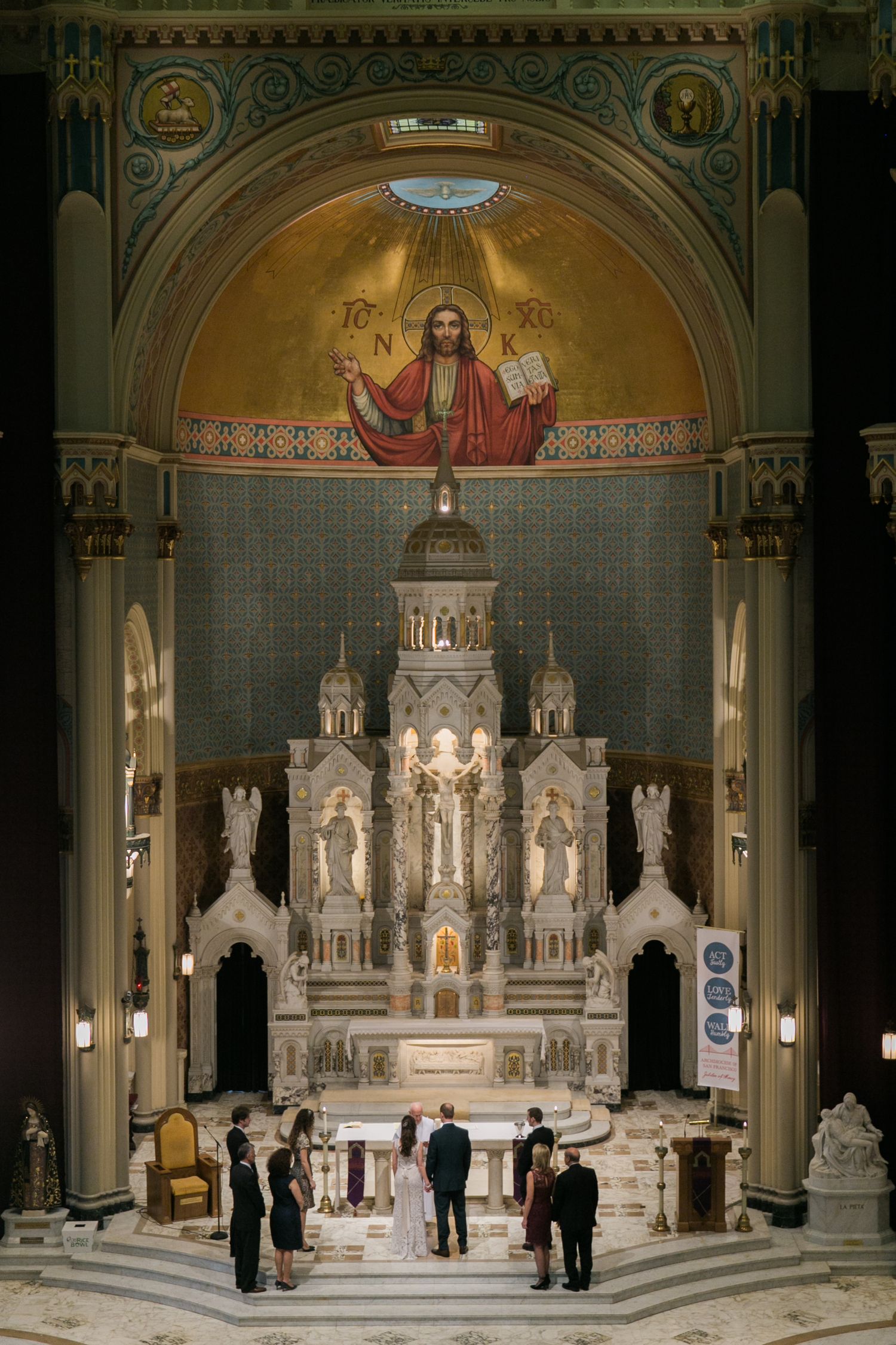 Interior of a grand ornate church with white marble altar and religious artwork.