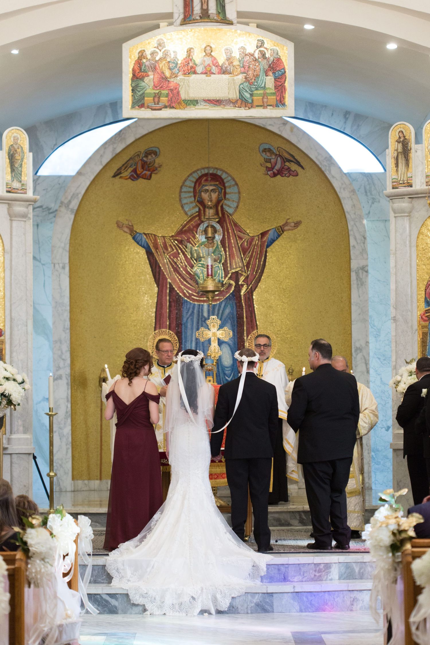 Traditional church wedding ceremony with golden religious icons and marble altar steps.