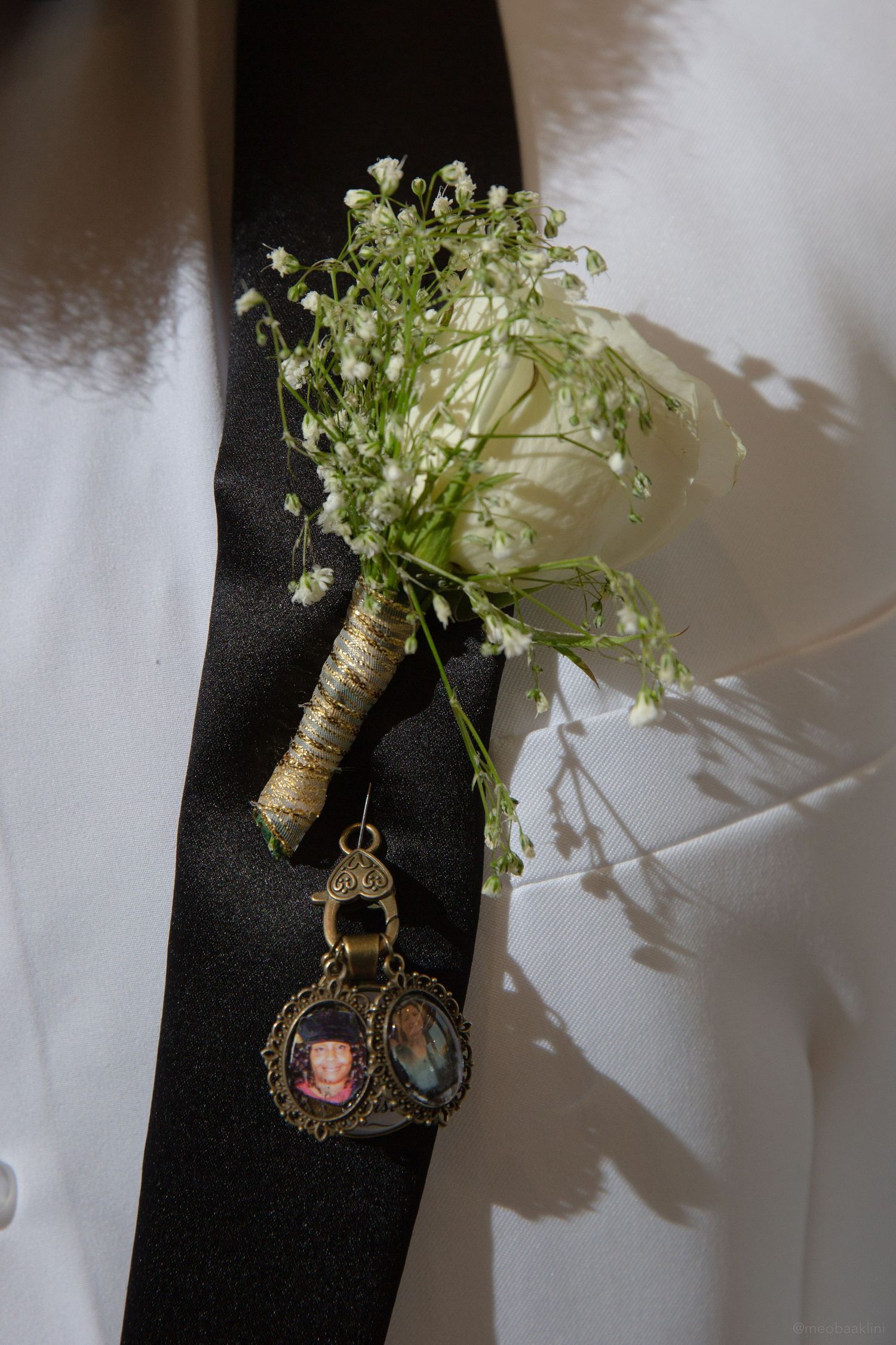 Delicate baby's breath boutonniere with a sentimental photo charm attached.