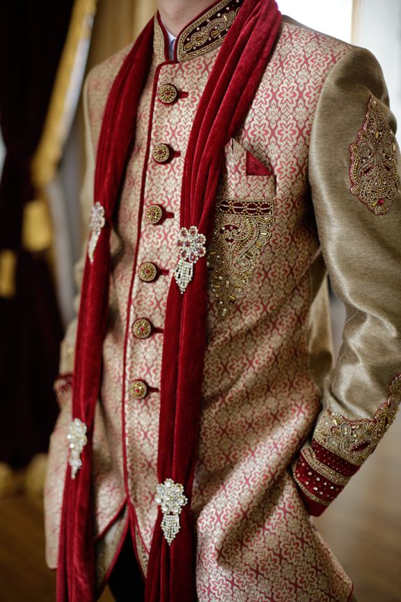 Traditional golden and red embroidered sherwani jacket with detailed floral patterns.
