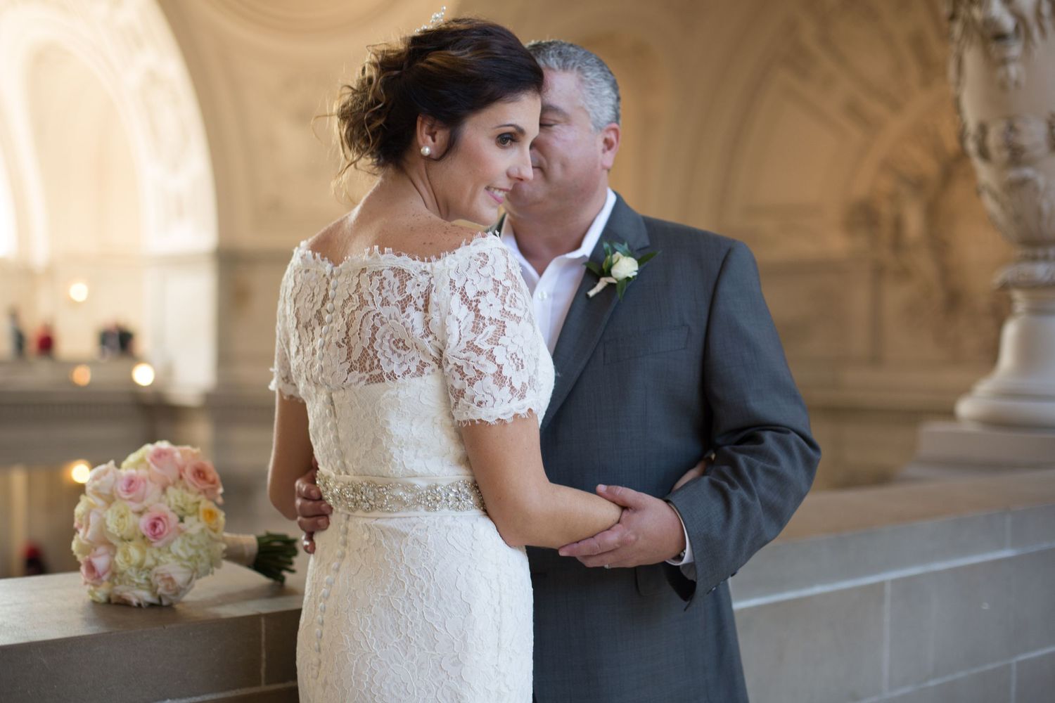 A romantic wedding moment captured under ornate archways with elegant decor.