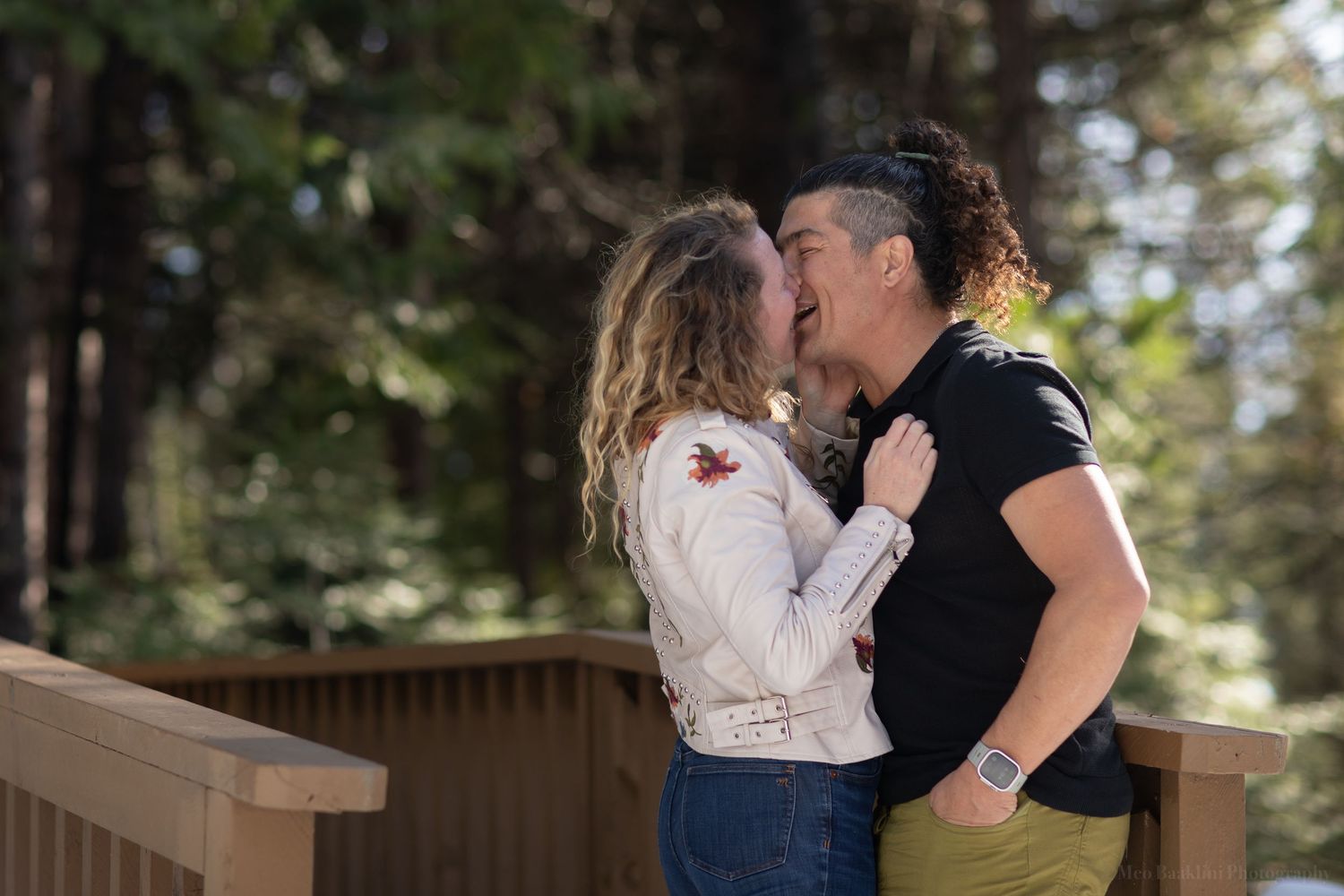 Romantic kiss on wooden deck with forest background.