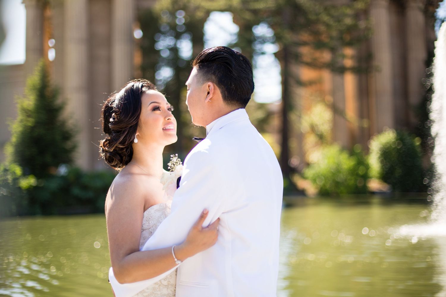 A tender moment between newlyweds beneath ornate classical architecture.