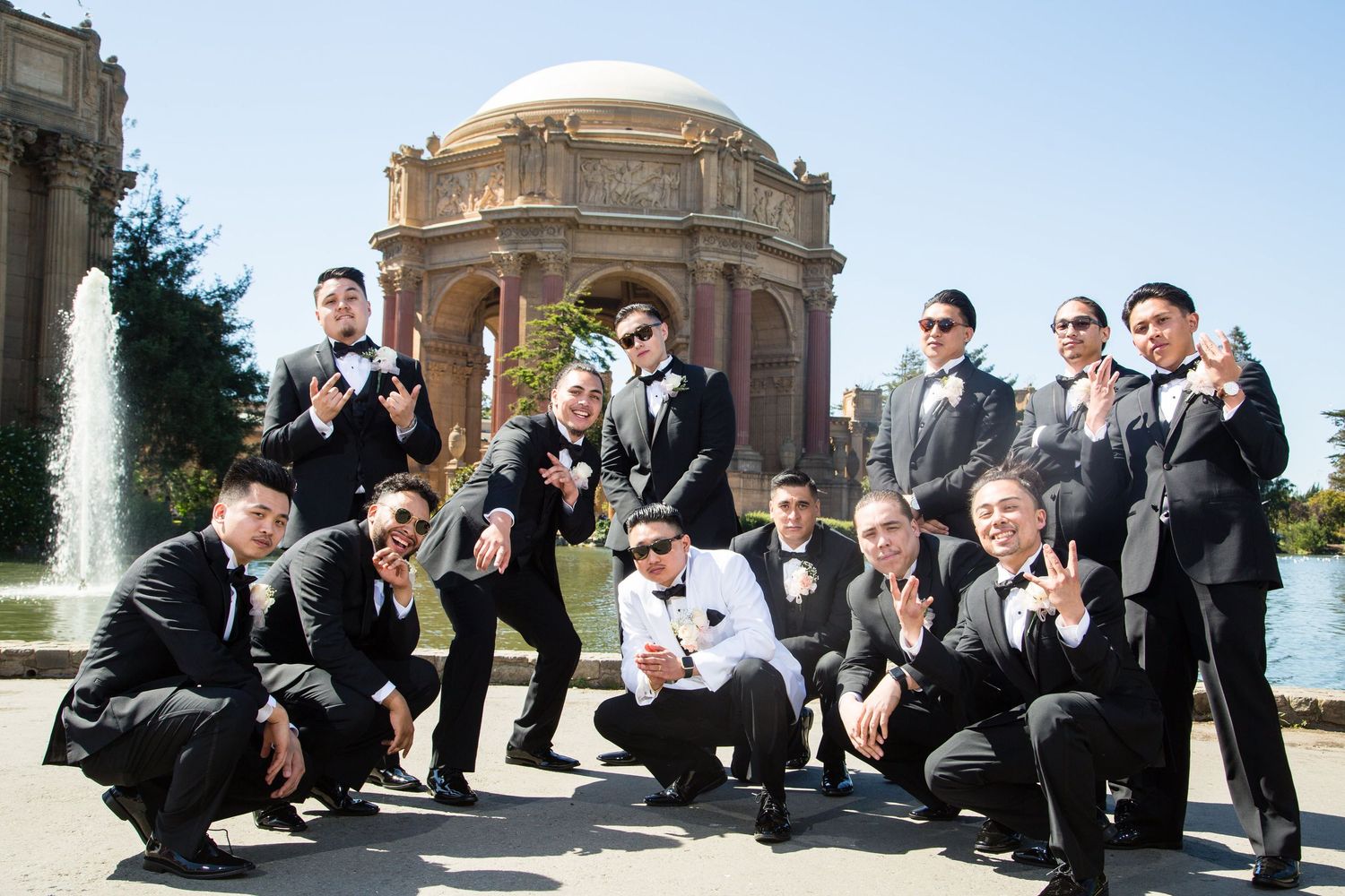 Wedding party poses dramatically in front of iconic Palace of Fine Arts in San Francisco.