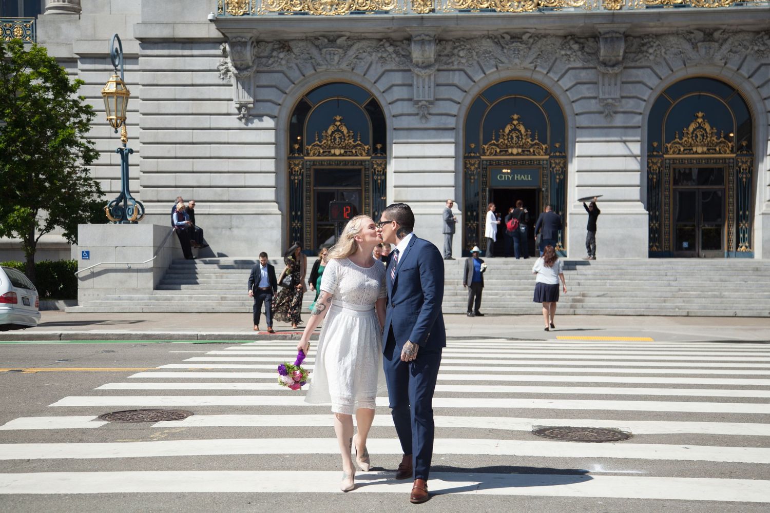 Couple sharing romantic moment on crosswalk in front of historic building.
