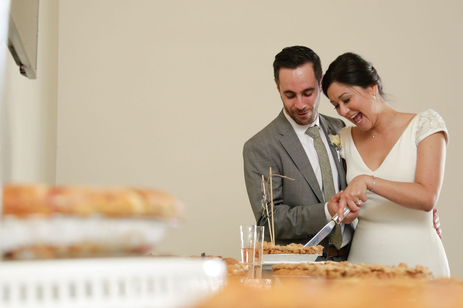 A couple cuts their wedding cake together at a reception.